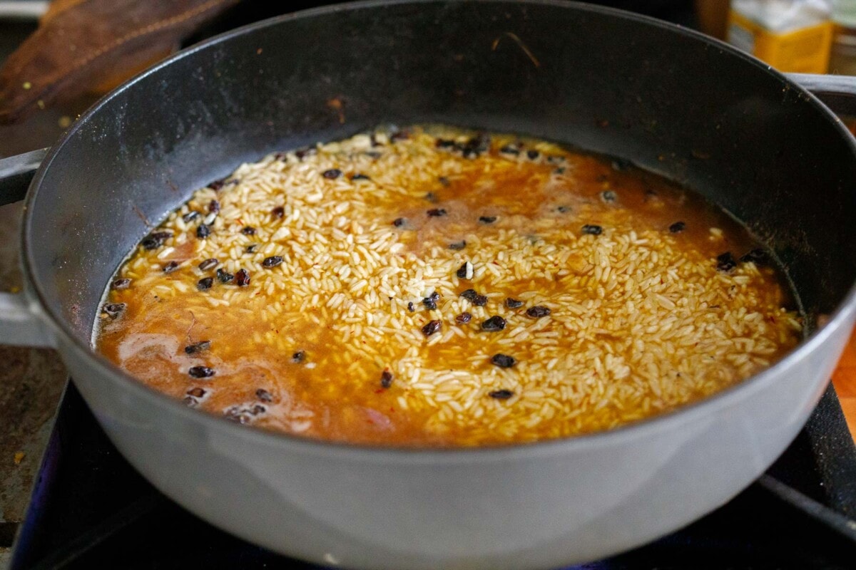 Jasmine rice cooking in dutch oven with saffron and barberries