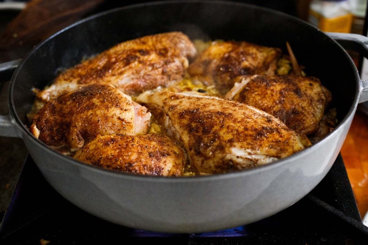 Persian chicken cooking in dutch oven with saffron rice