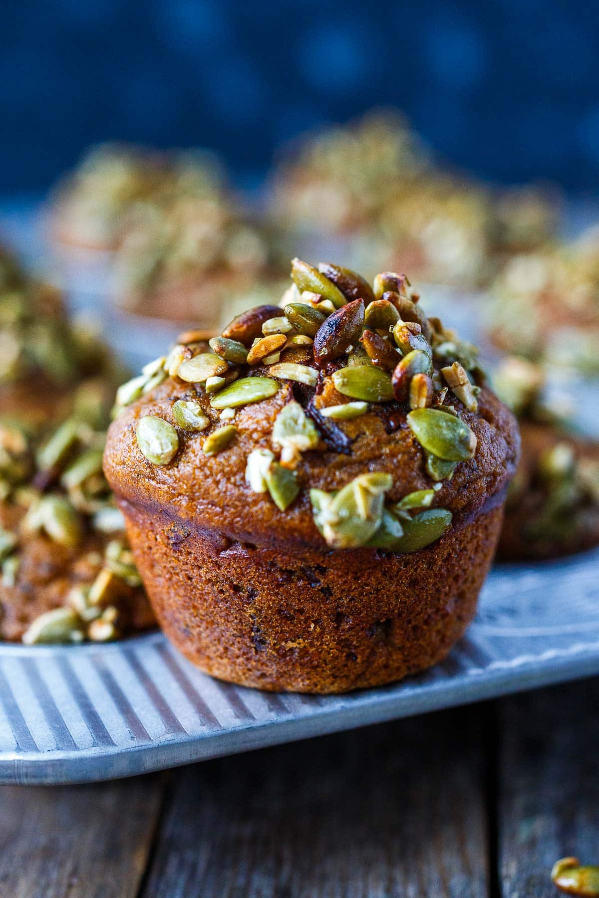 Pumpkin Muffin up close topped with pumpkin seeds. 