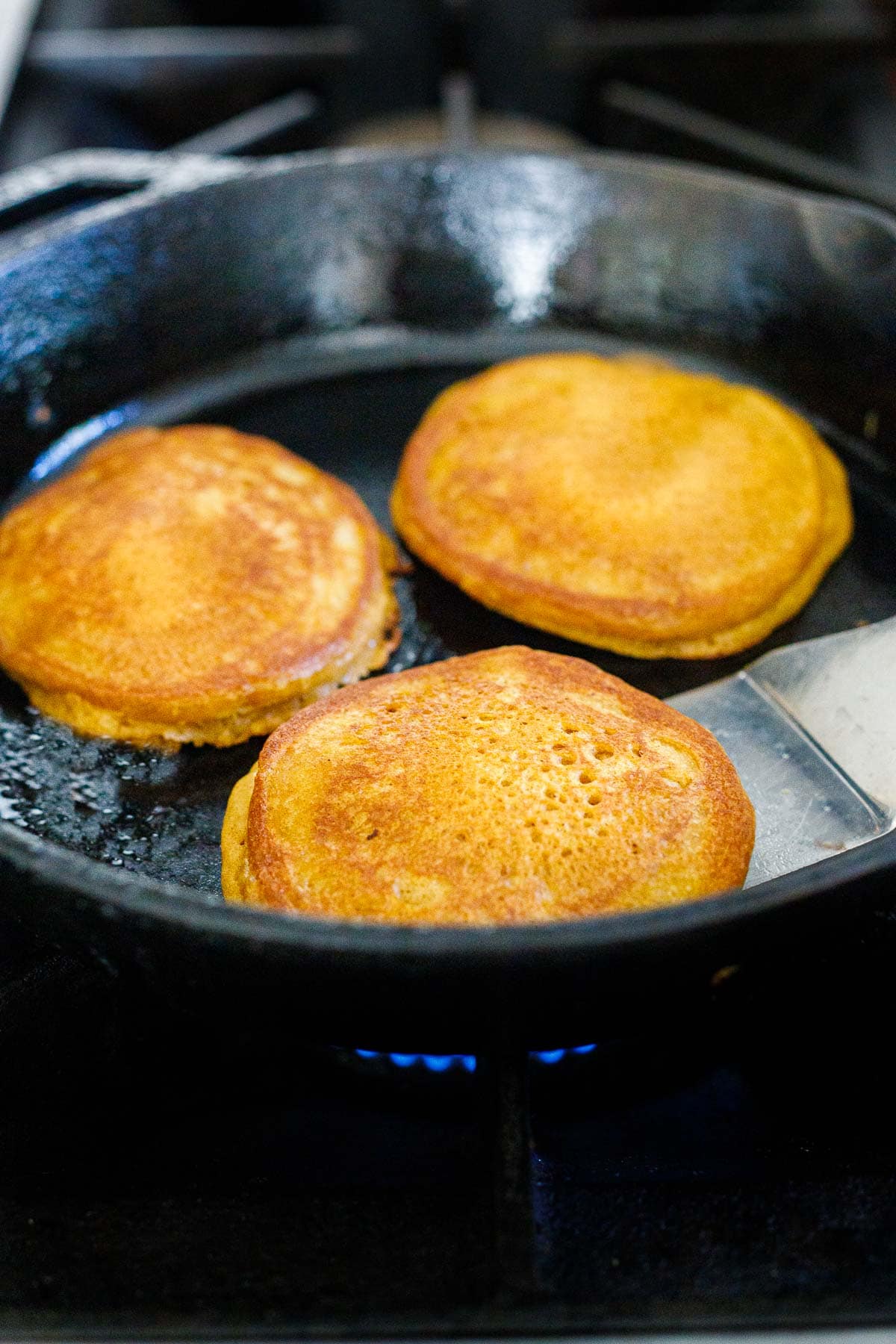 fluffy pumpkin pancakes cooked on cast iron skillet