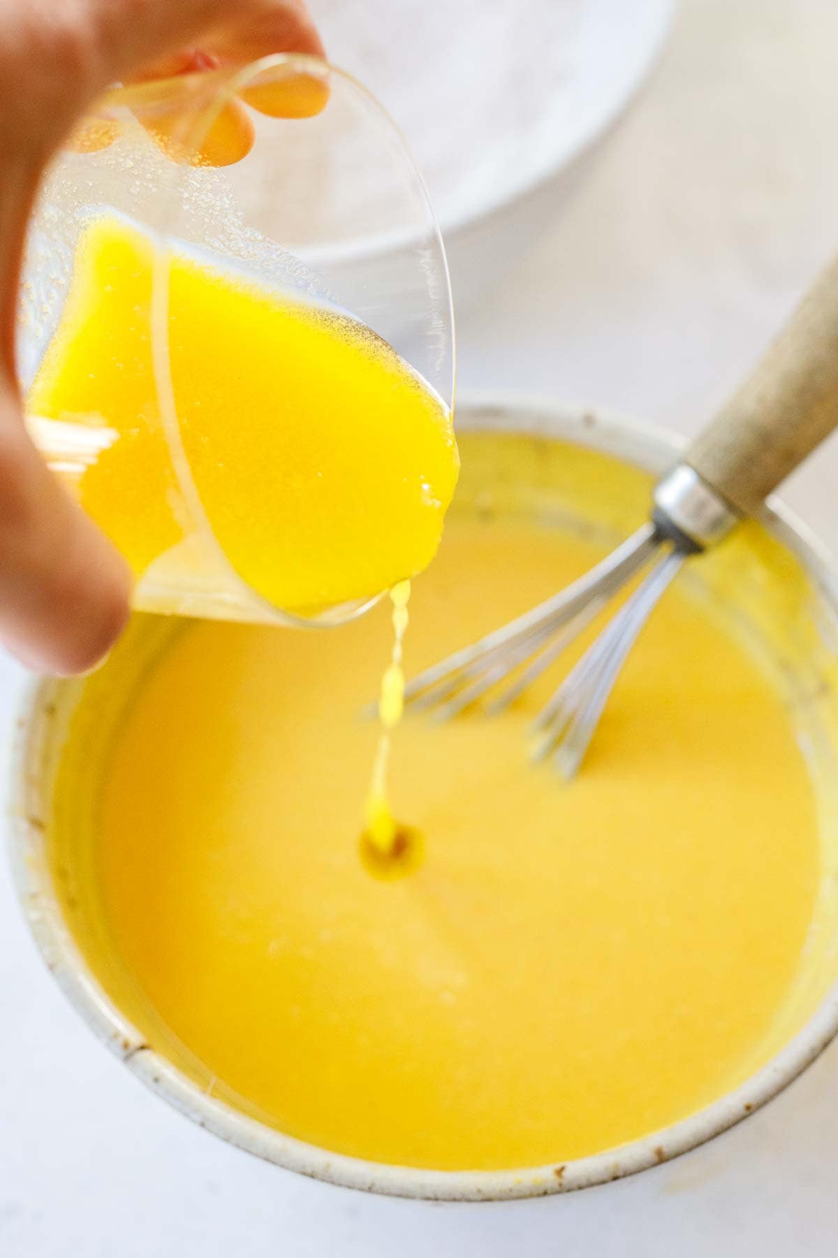 melted butter pouring into bowl of wet ingredients