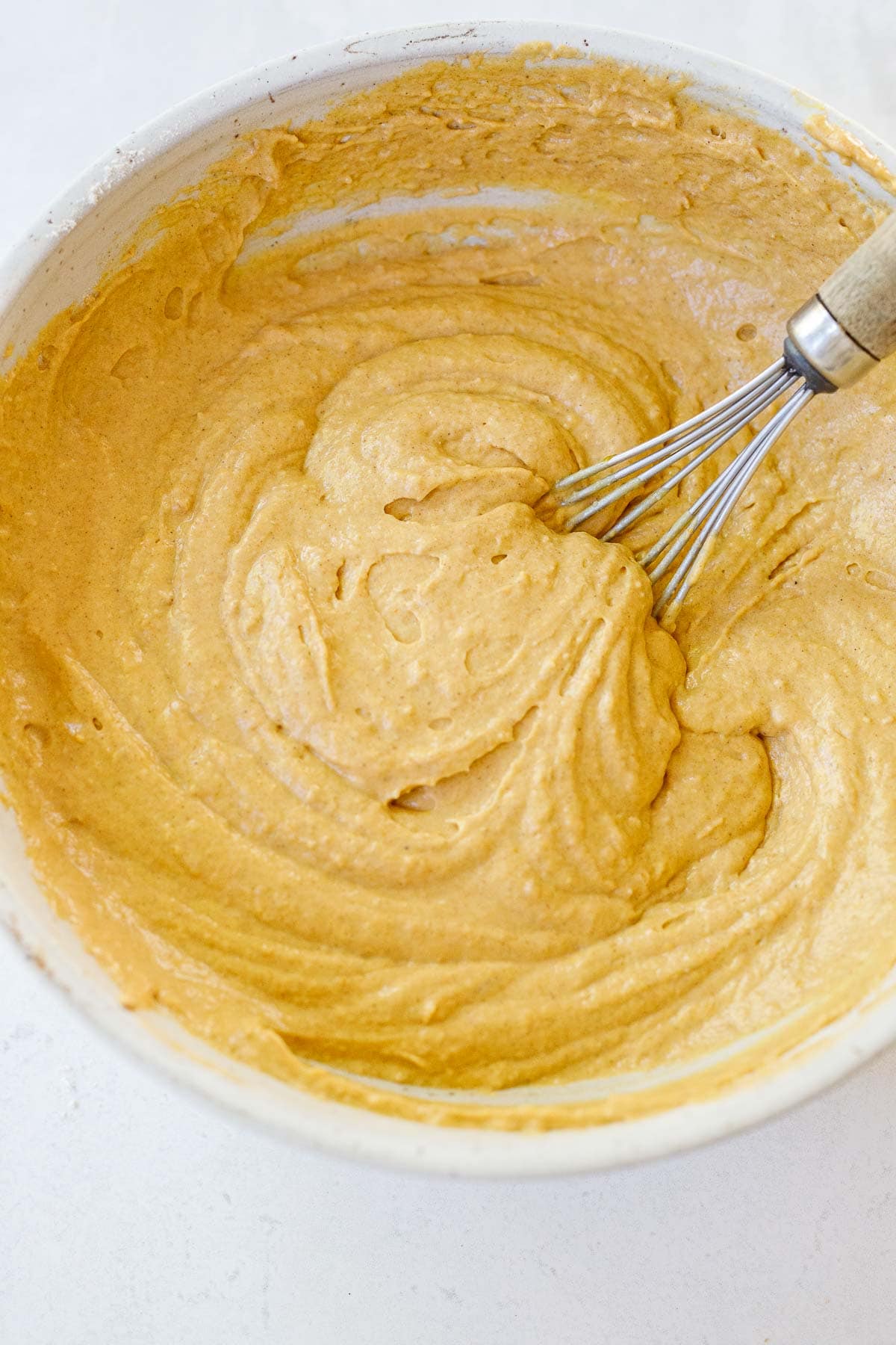 pumpkin pancake batter fully mixed together in bowl with whisk