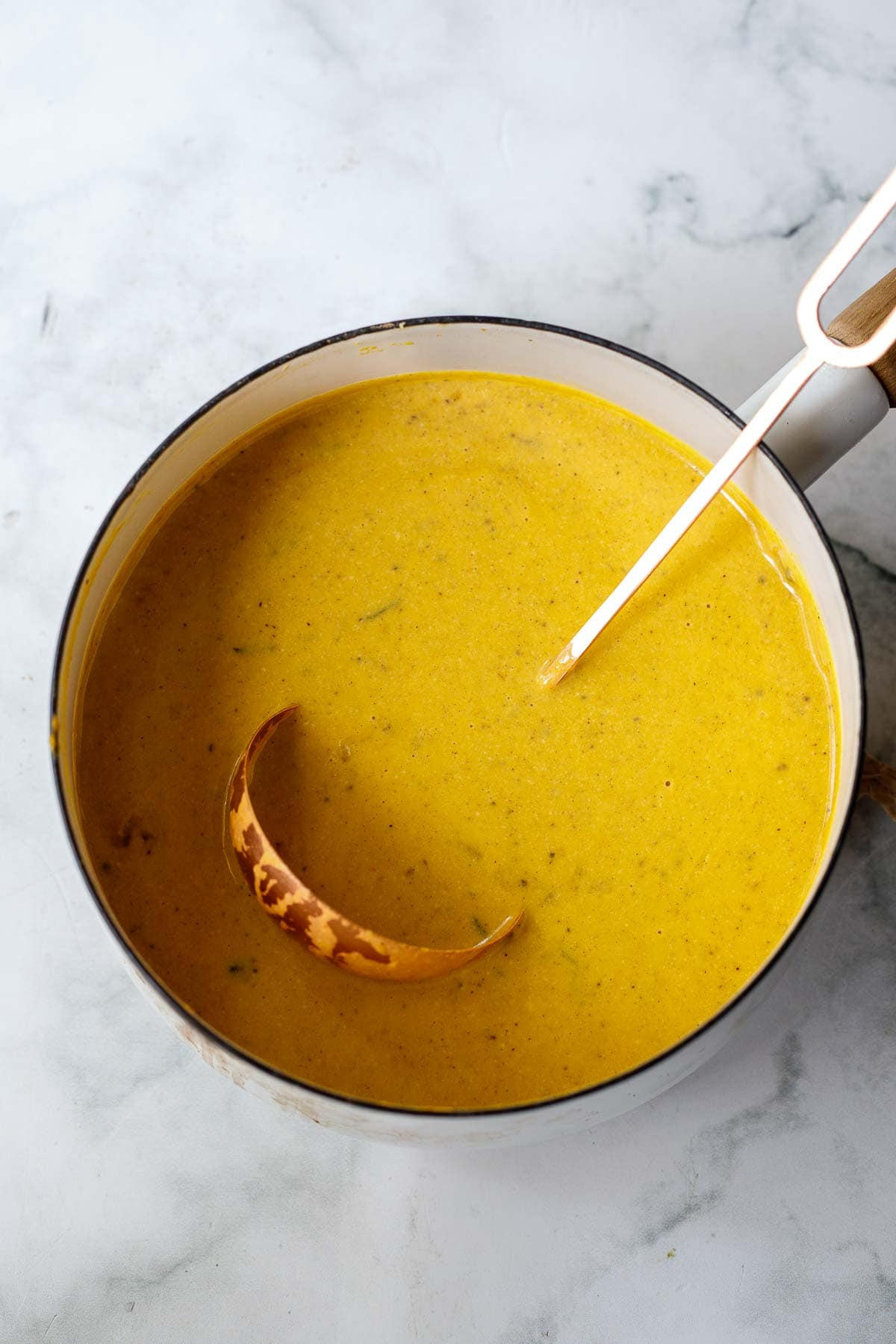 pot with creamy pumpkin pasta sauce and a ladle