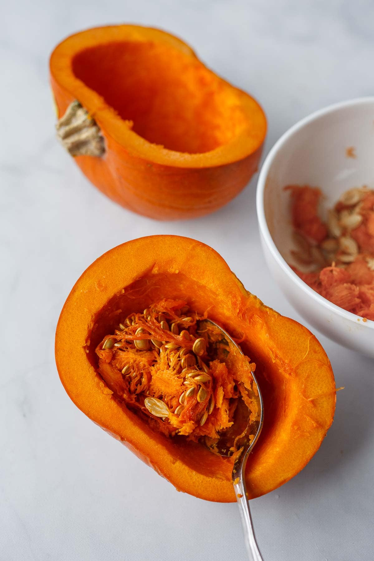 Scooping seeds out of a pumpkin for pumpkin curry.