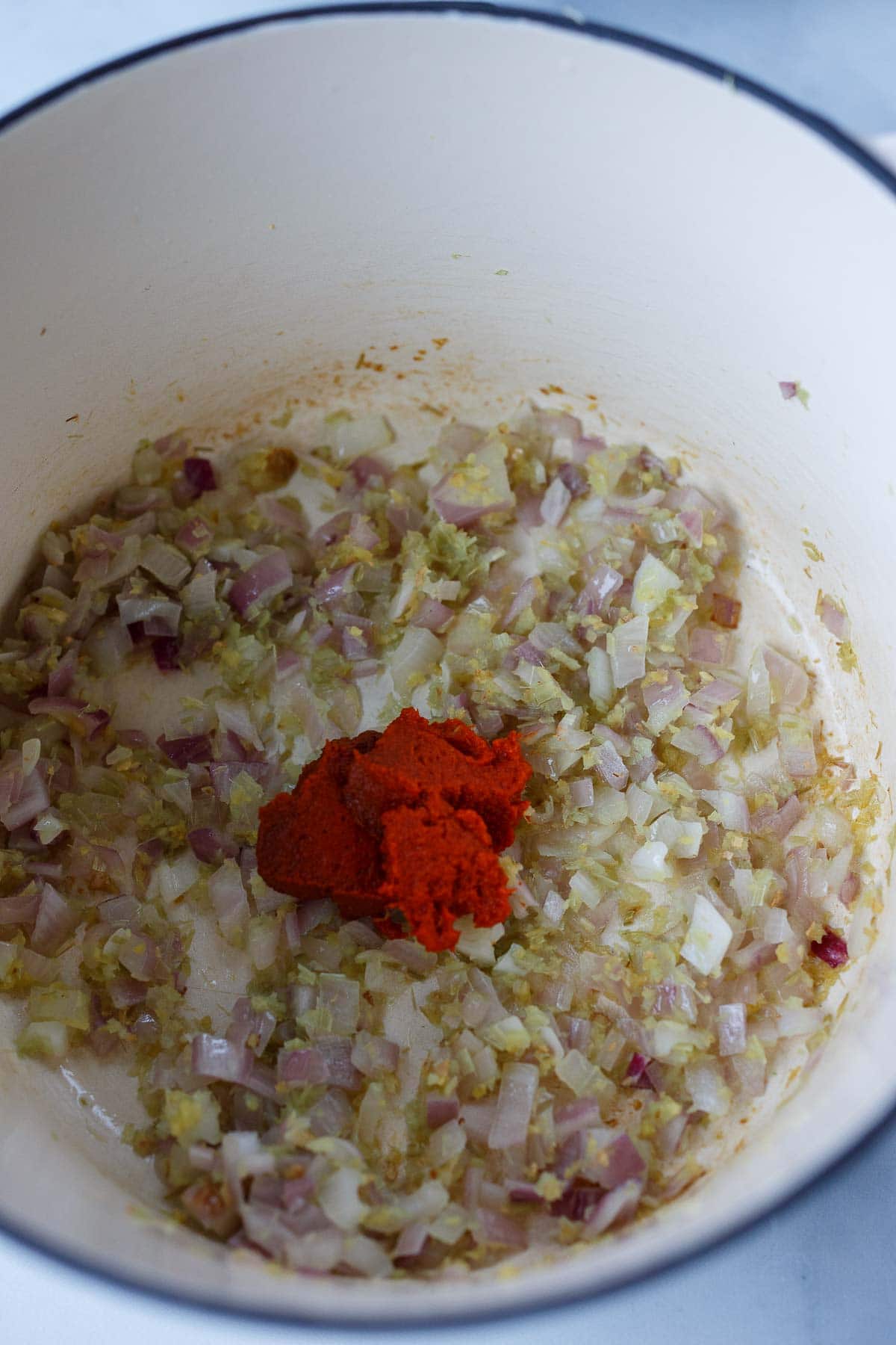 Red curry paste, shallots, ginger, and lemongrass sauteing for pumpkin curry.