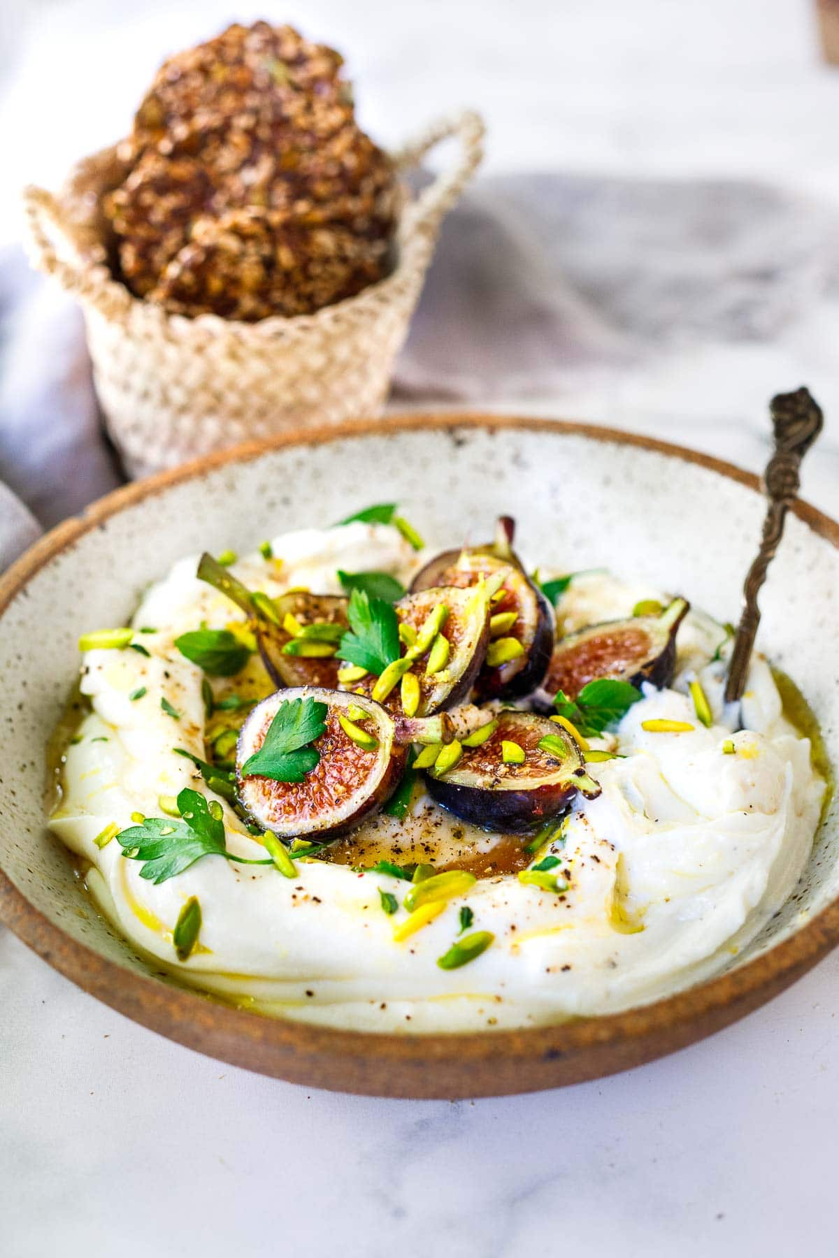Whipped Ricotta in a bowl with figs and honey and pistachio.