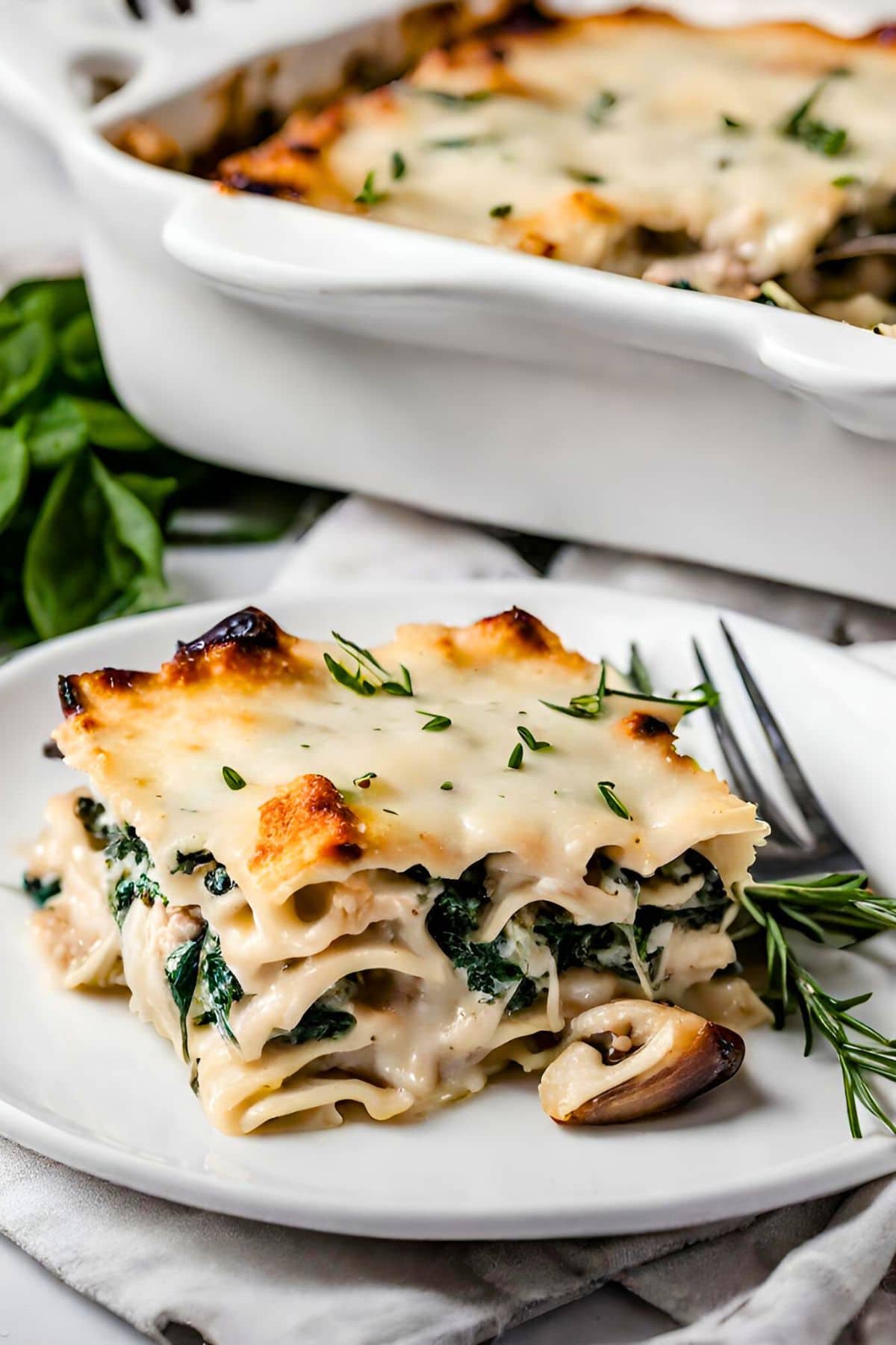 A delicious, cozy recipe for Chicken Lasagna with mushrooms, spinach and rosemary in a creamy Béchamel Sauce. A hearty meal perfect for special gatherings or Sunday supper. Vegetarian-adaptable.