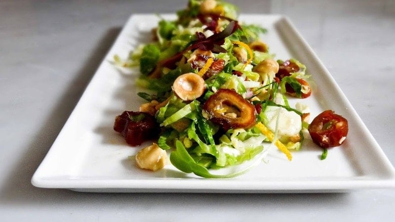 A simple tasty recipe for raw Brussel Sprout Salad with Hazelnuts and dates, vegan, healthy and a great combination of flavors. | www.feastingathome.com