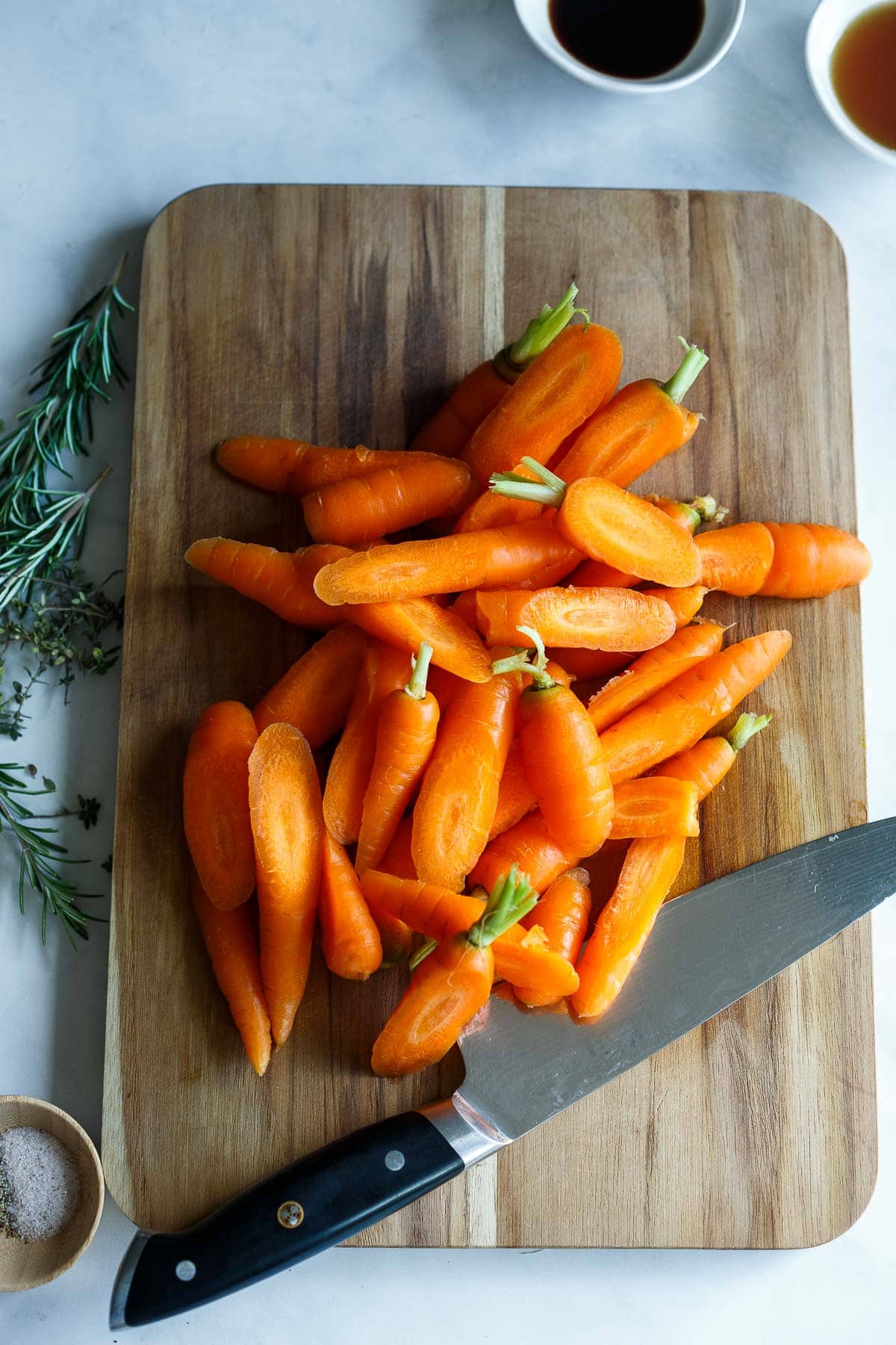 Sliced carrots on a cutting board for glazed carrots.