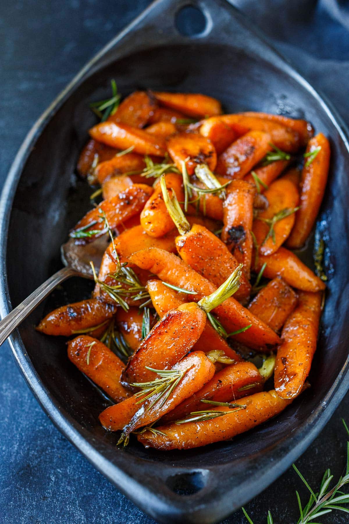 Glazed carrot recipe in a black serving dish. 