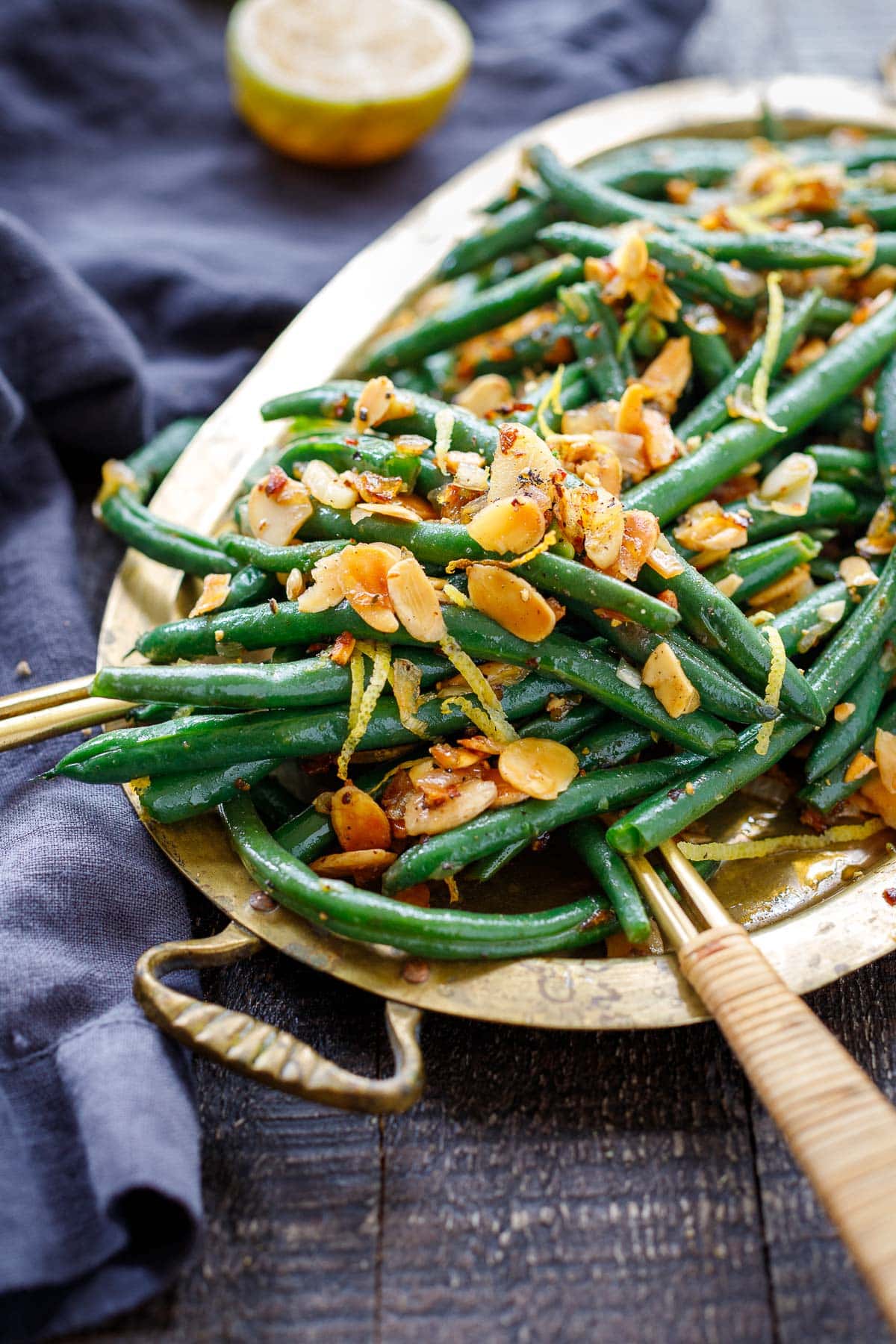 This Green Beans Almondine recipe is so simple yet full of incredible flavor! Toasty almonds, crispy garlic, lemon zest, shallots, and chili pepper flakes bring it up a notch! Vegan.