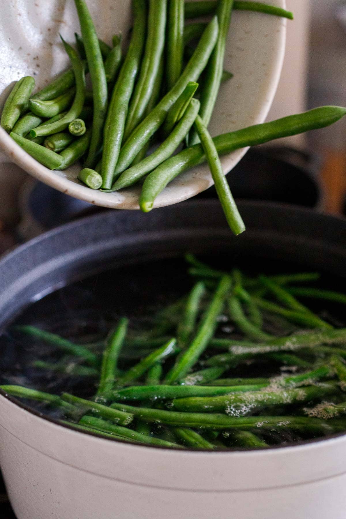 trimmed green beans tossed into pot of boiling water