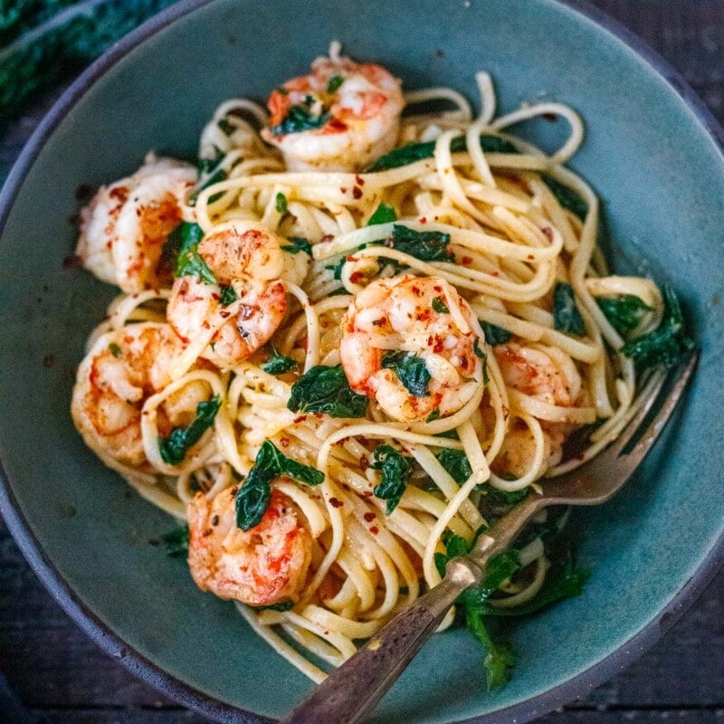 This Shrimp Pasta recipe is fast, easy and full of punchy flavor! Olive oil, lemon zest, fresh garlic, kale and red pepper flakes keep it light and flavorful. A delicious pasta dinner, ready in under 30 minutes.
