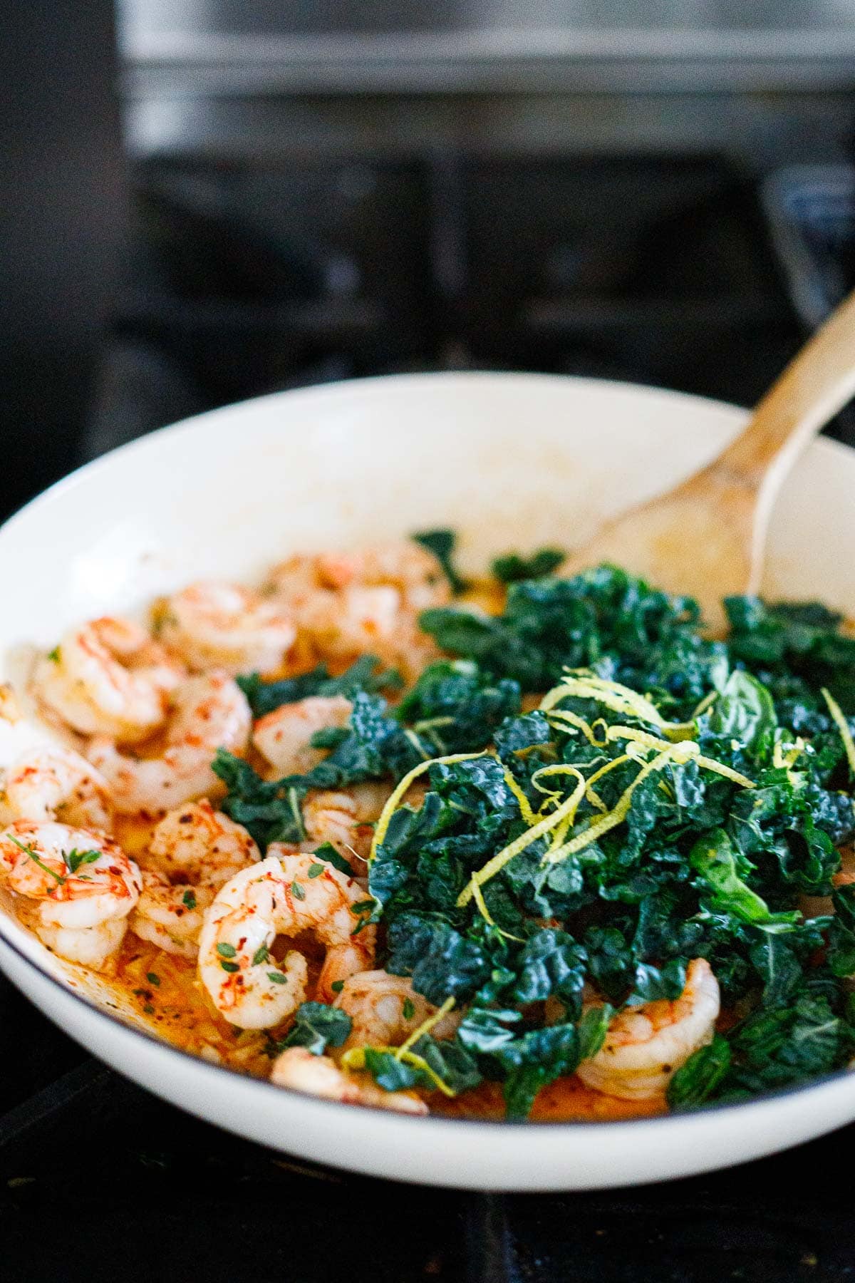 fresh kale and lemon zest added to pan with shrimp