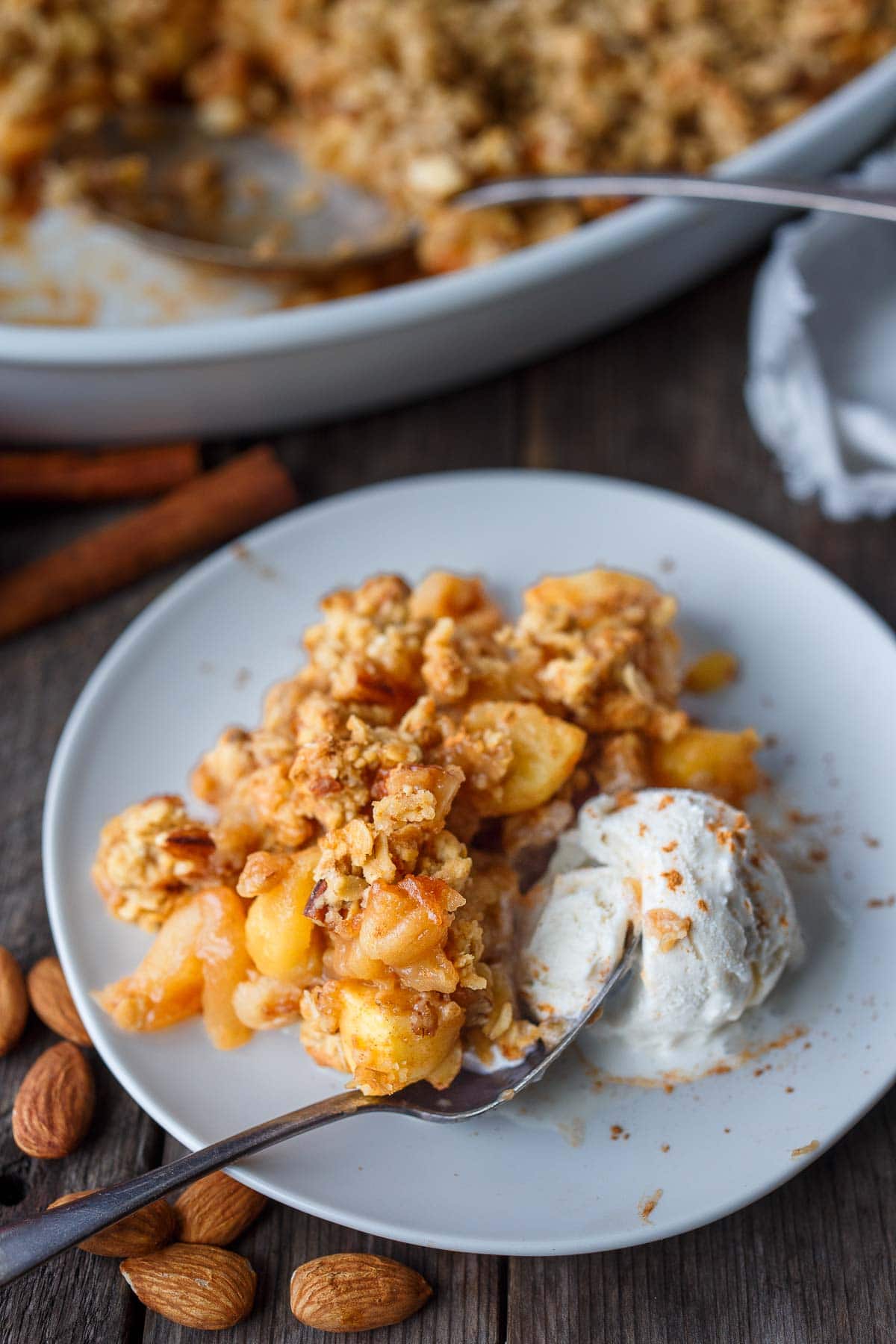 Apple crisp on a plate with ice cream.