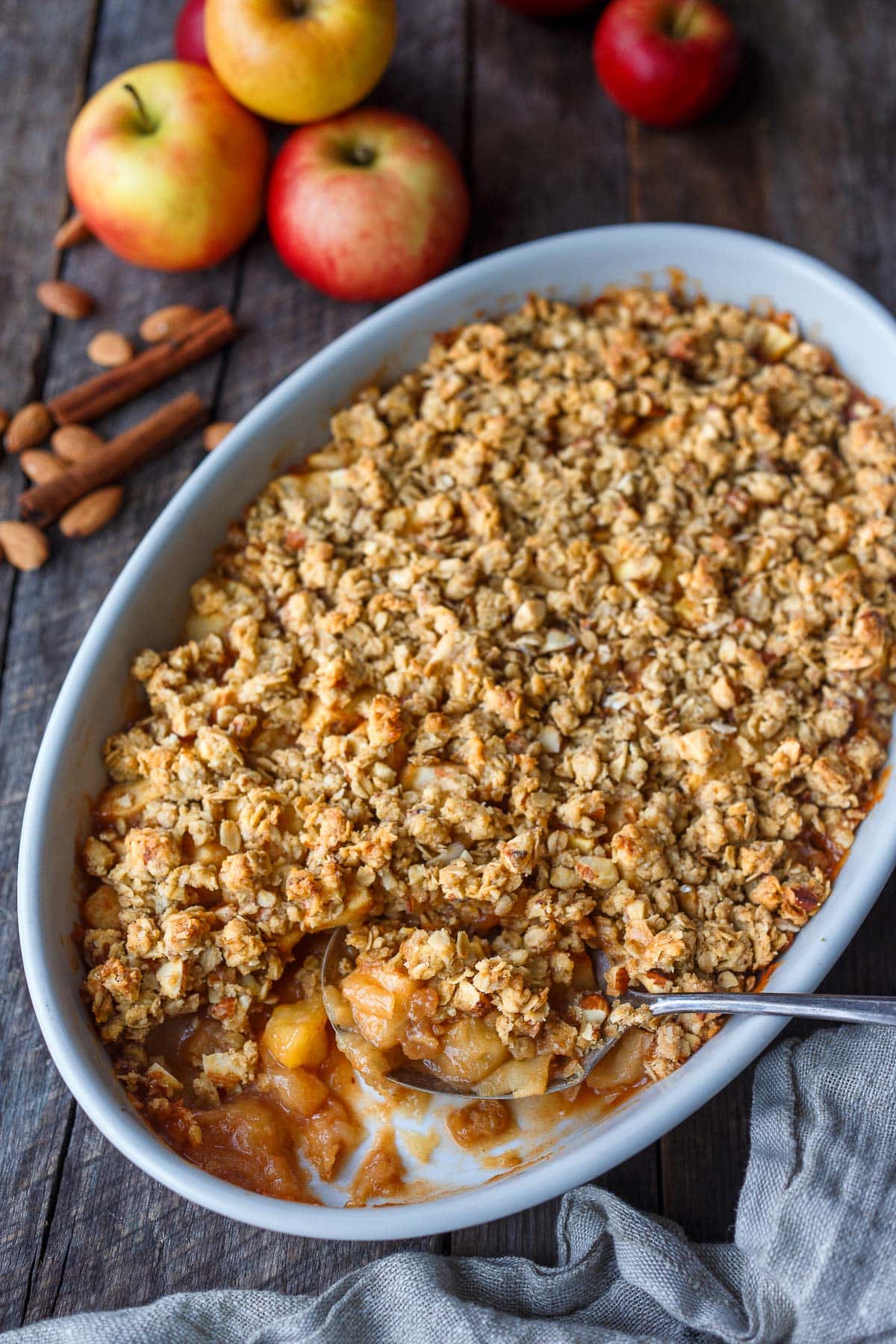 This easy Apple Crisp recipe is so cozy! Deliciously spiced baked apples with a crunchy oat & nut topping that is easy to make! Vegan and gluten-free adaptable.