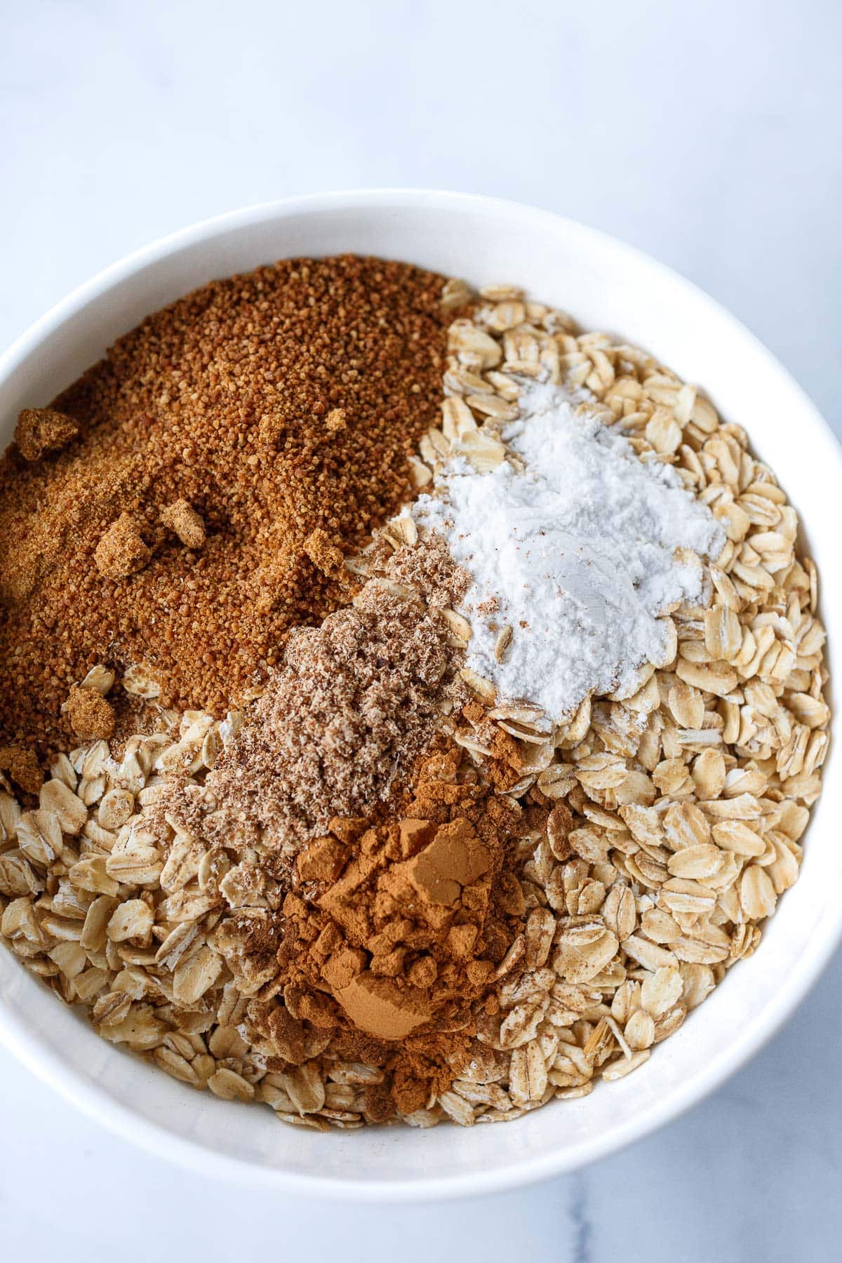 oats, cinnamon, sugar, baking powder, nutmeg in mixing bowl