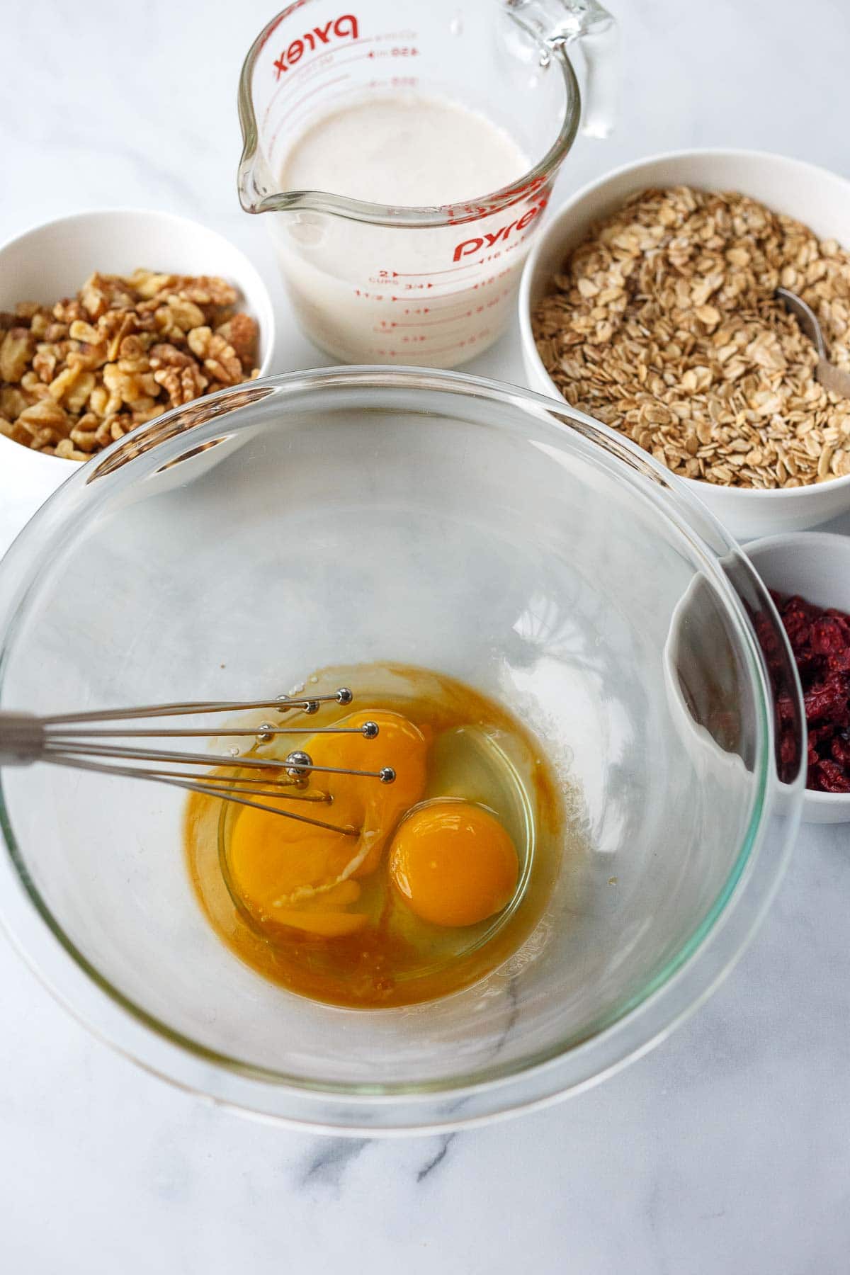 whisking eggs in glass mixing bowl