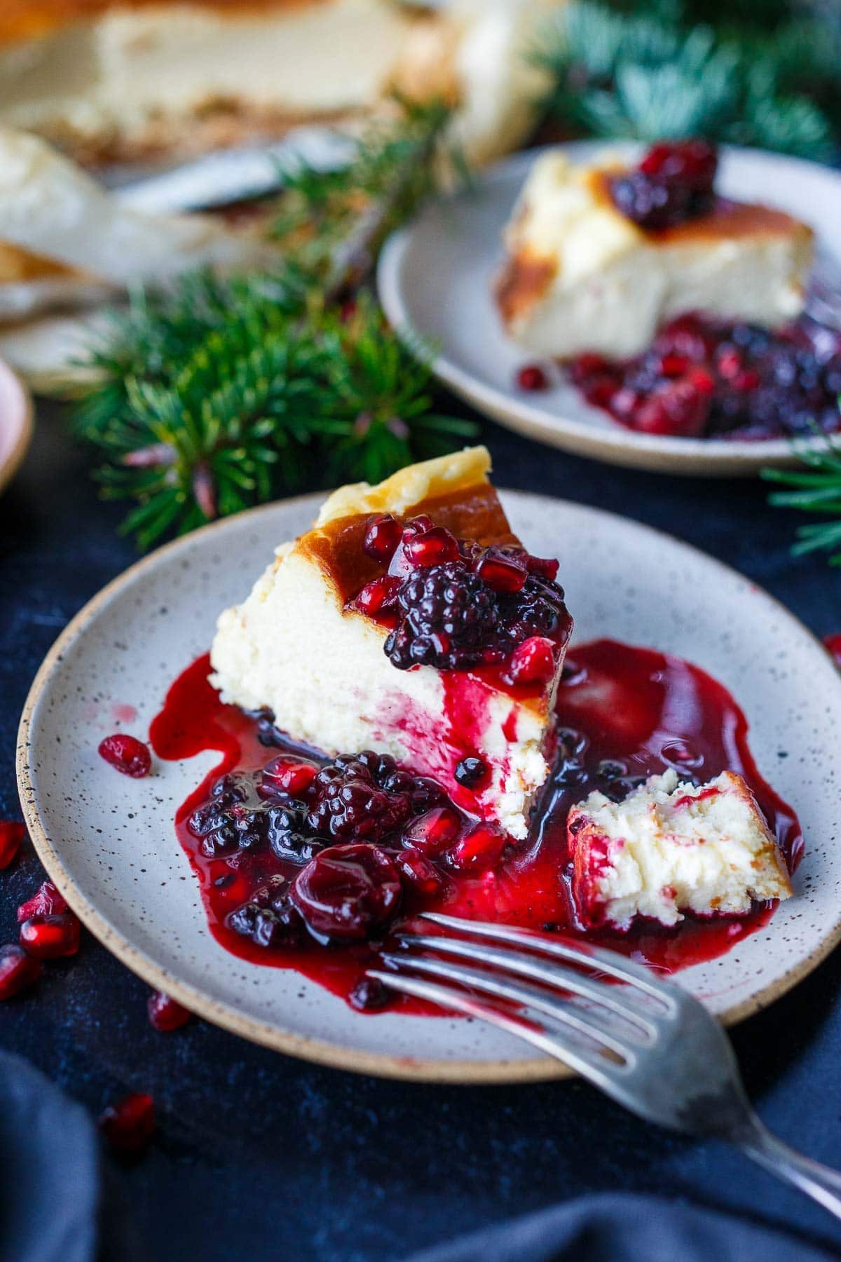 slice of basque cheesecake on plate with berry compote on top