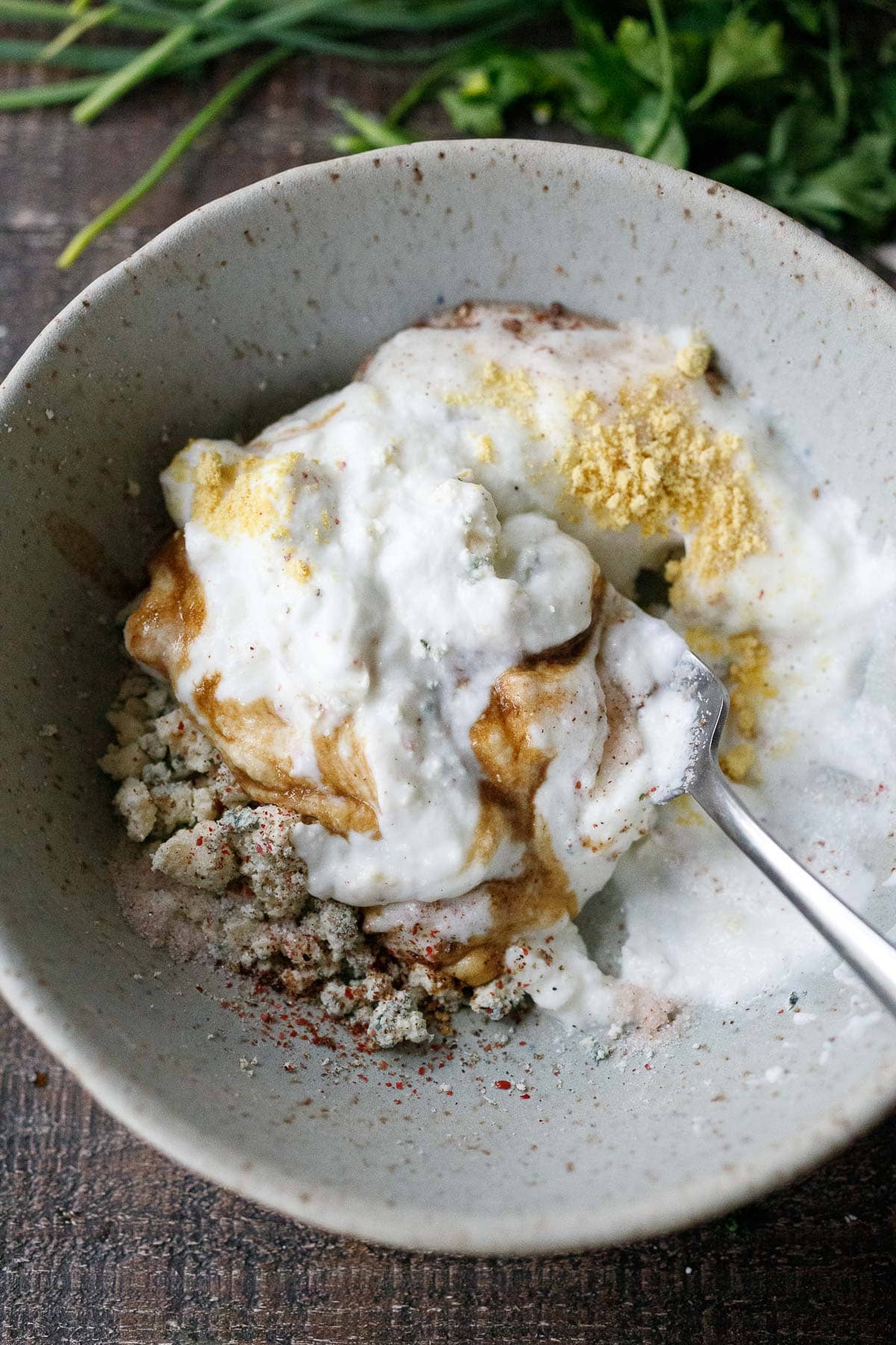 yogurt, worcestershire, dried mustard added to bowl of crumbled blue cheese 