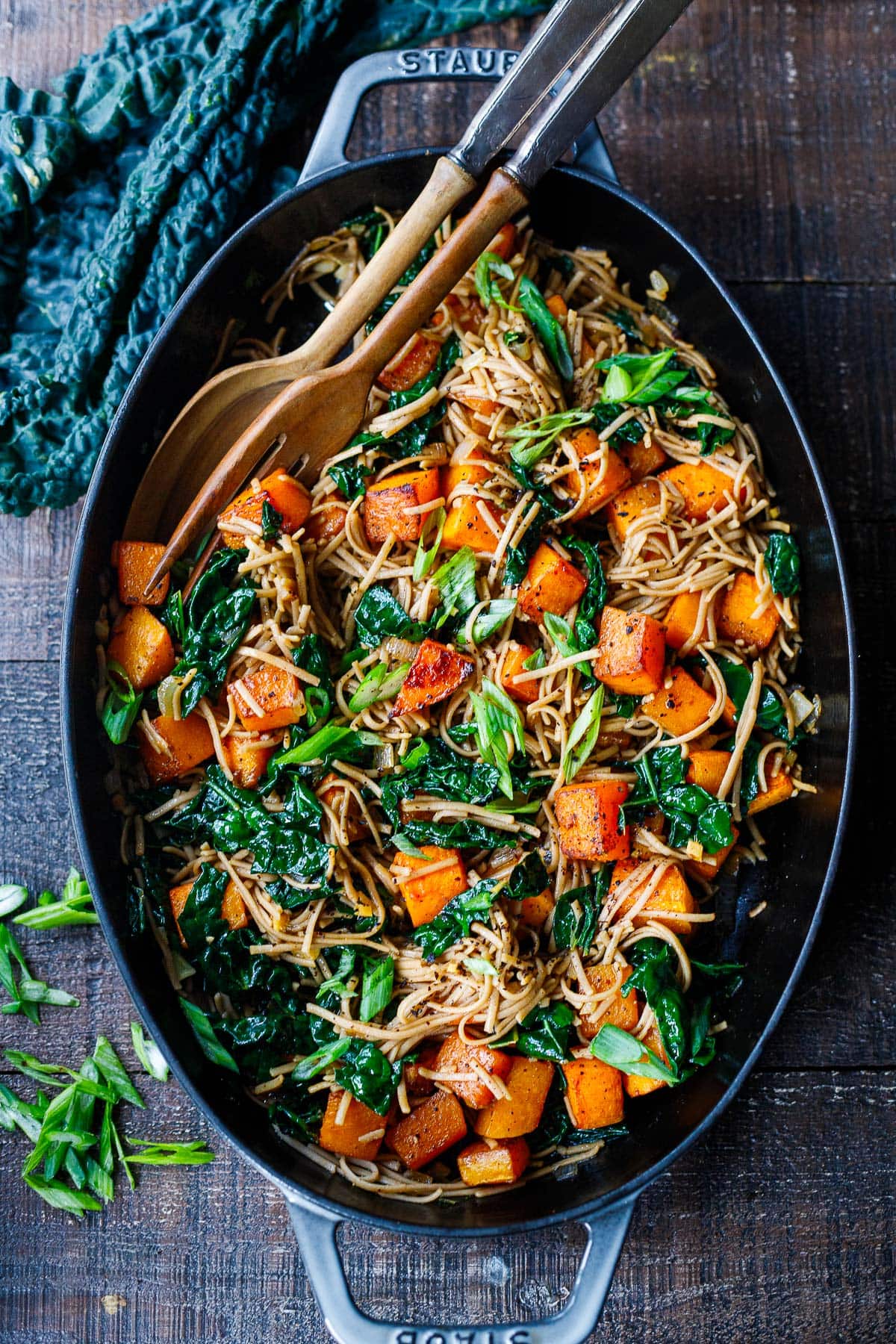 butternut squash soba noodles with kale and scallions in large serving dish with utensils
