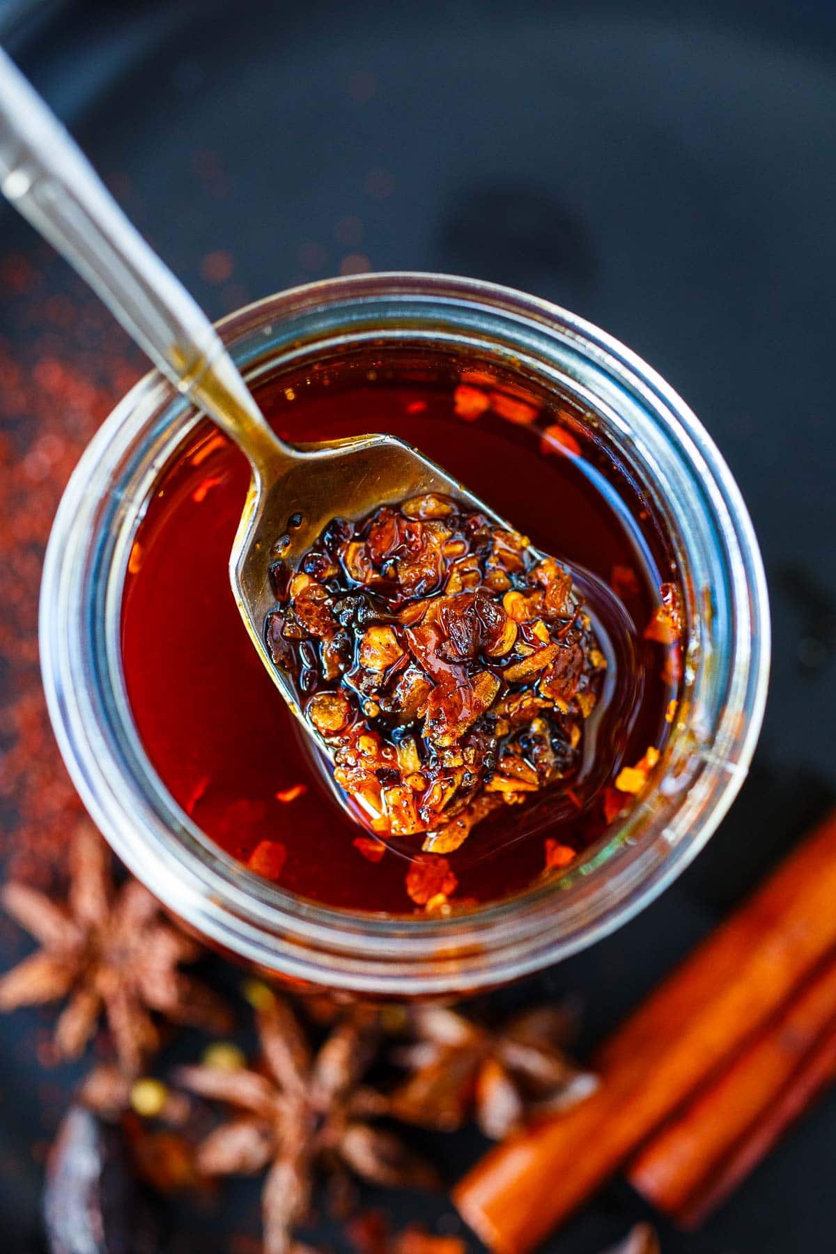 spoonful of chili crisp lifted from oily jar of condiment.