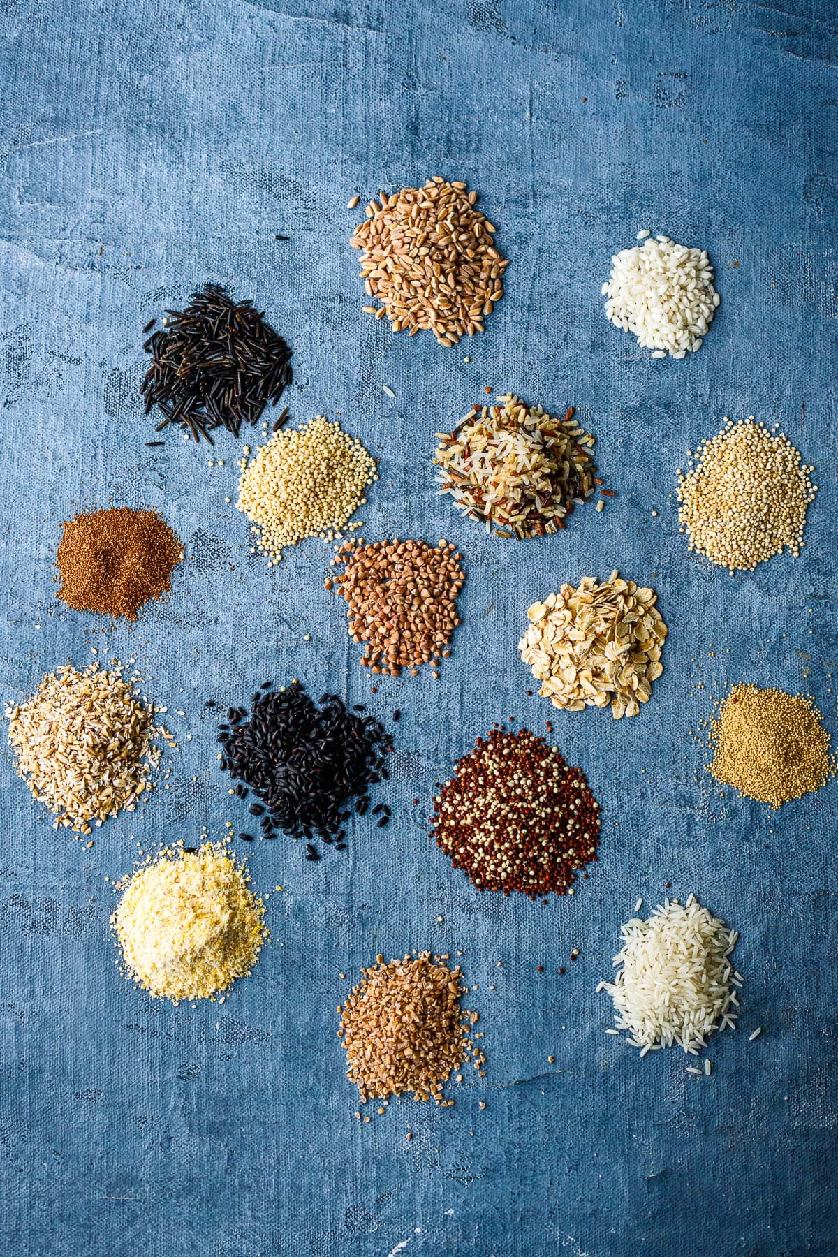 a variety of whole grains on a blue surface