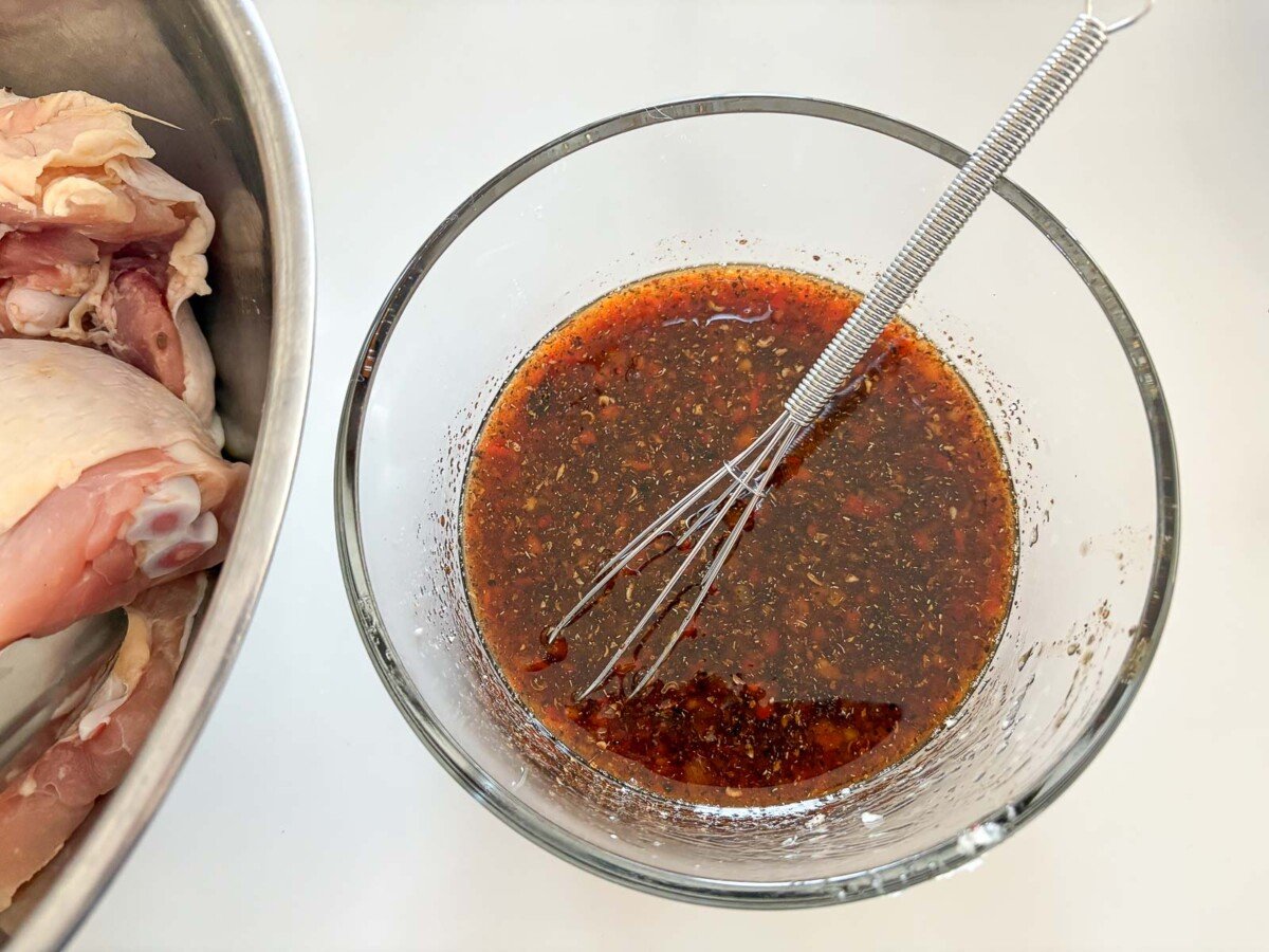 small glass bowl with whisk and szechuan marinade.