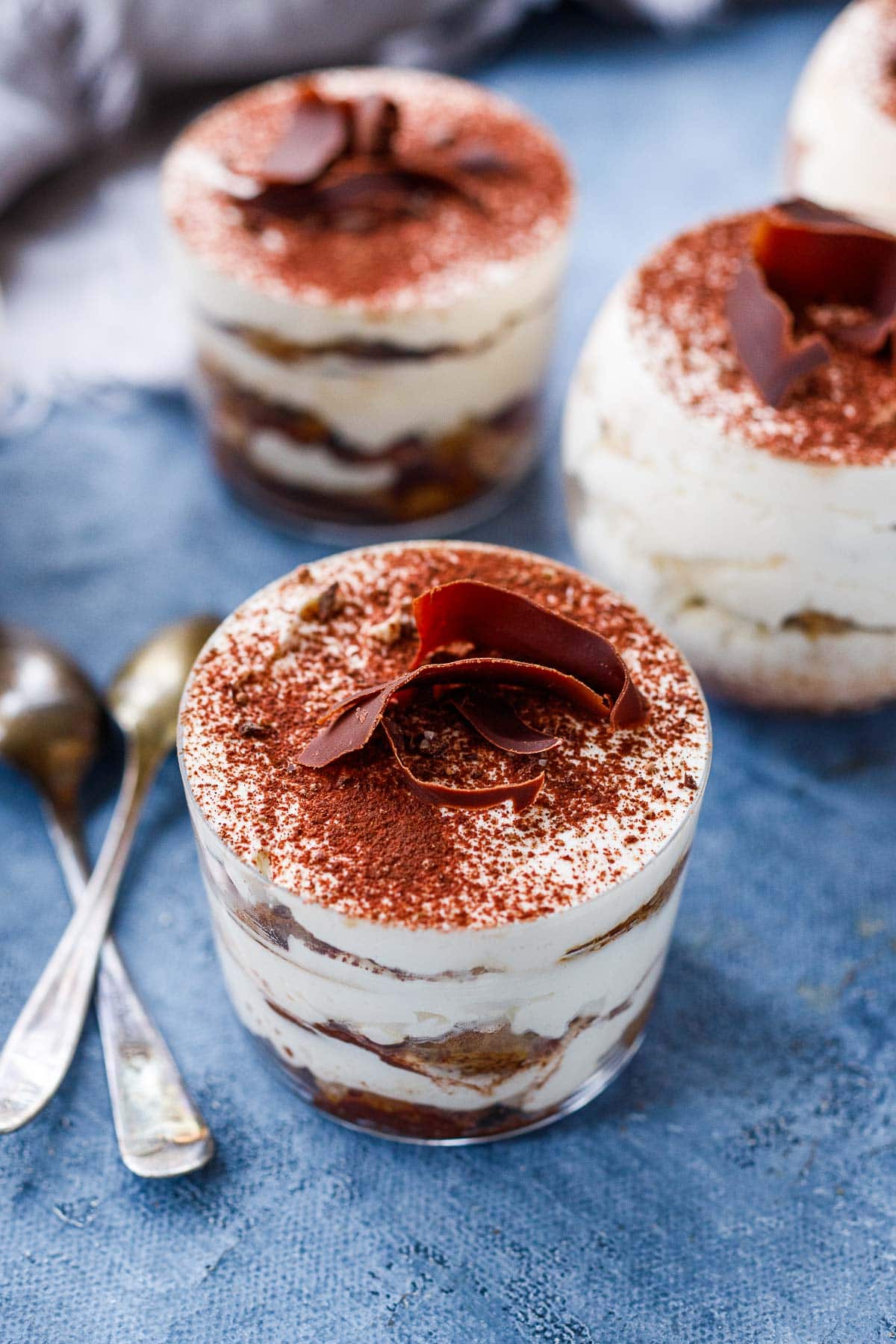 tiramisu in glass jar with cocoa powder dusting on top and a chocolate shaving garnish