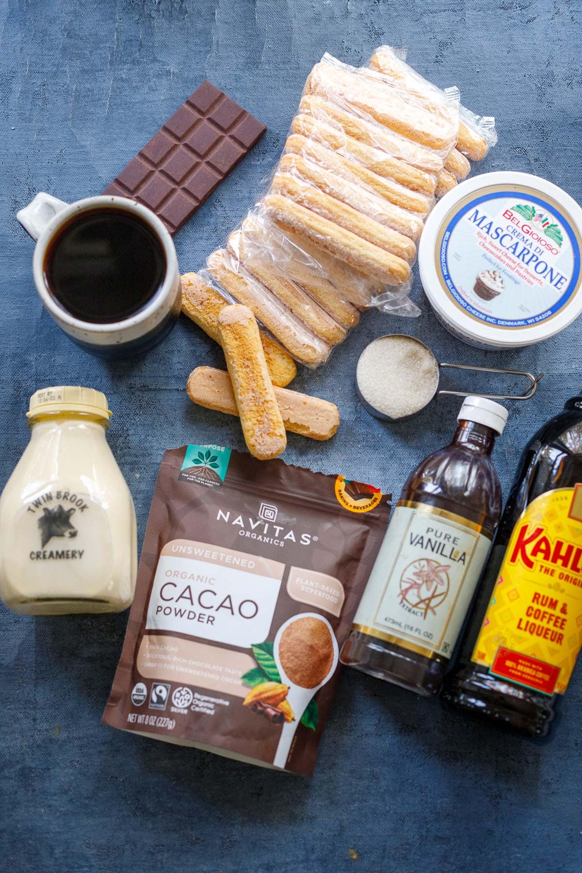 ingredients for tiramisu on table - coffee, ladyfingers, chocolate, mascarpone, sugar, cream, cacao powder, vanilla, Kahlua