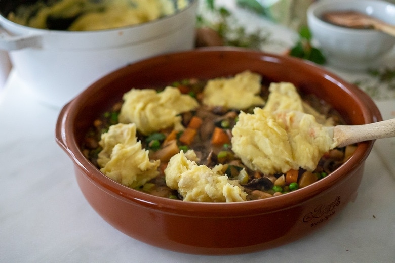 Top with dollops of the mashed potatoes, then spread them out.