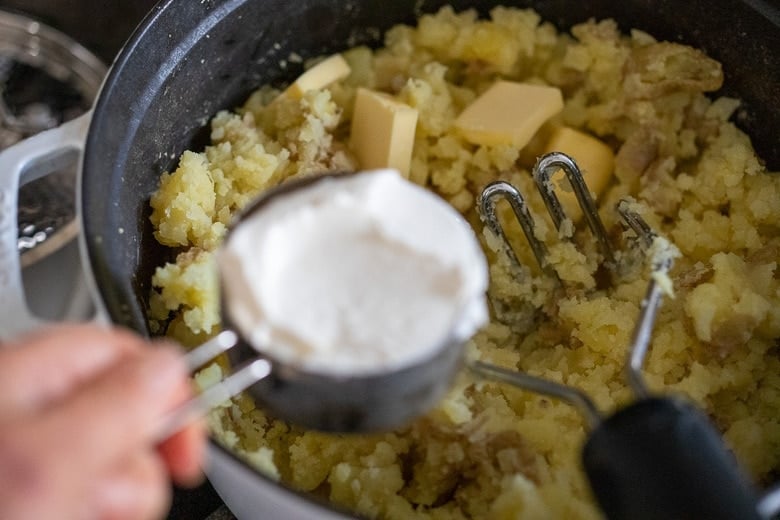adding sour cream and butter to the potatoes
