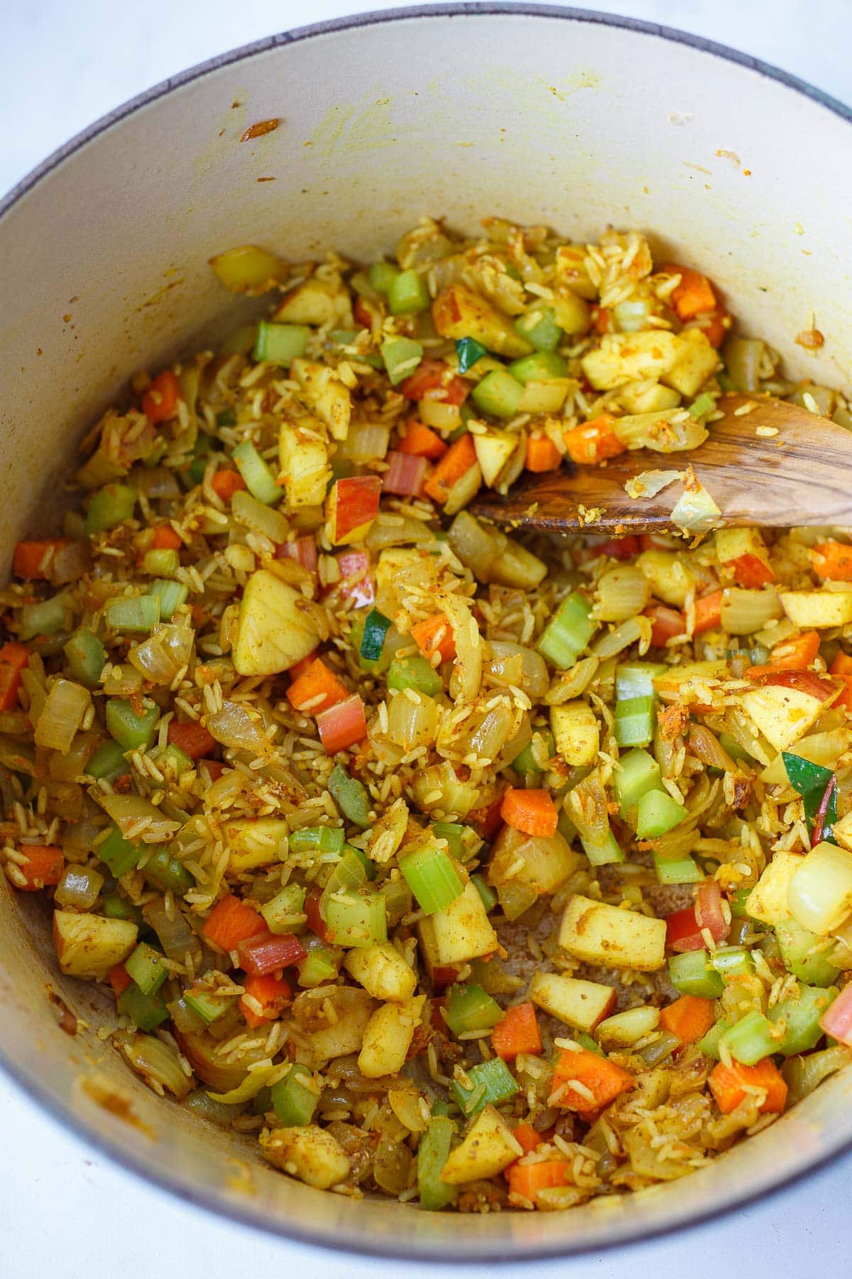 soup pot with diced vegetables and rice to make chickpea soup, mixed with turmeric.