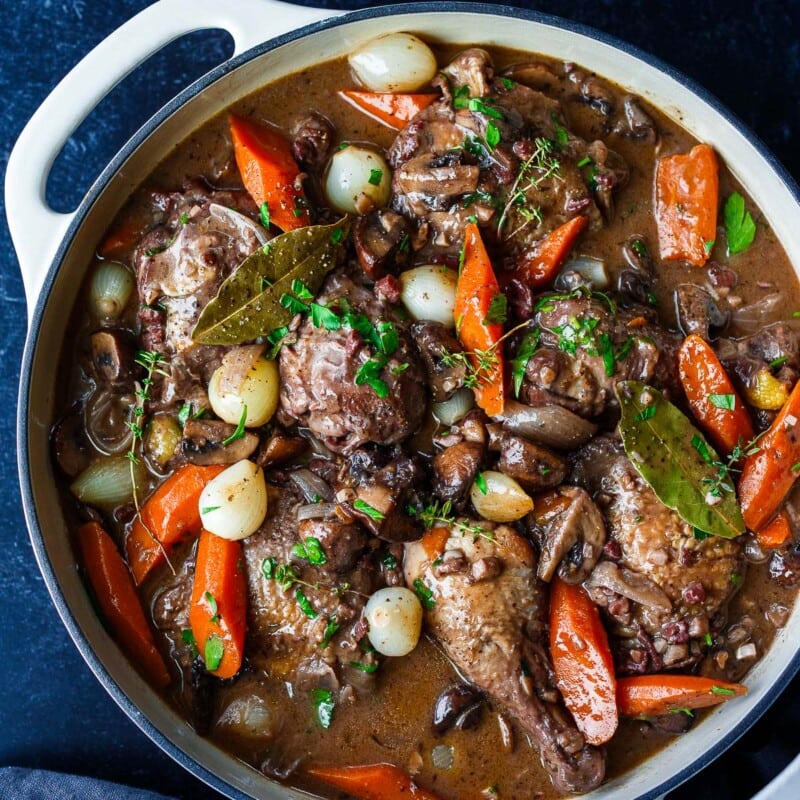 Easy & delicious, Coq Au Vin is a French chicken stew braised in a red wine sauce with cremini mushrooms, onions, carrots, and herbs.
