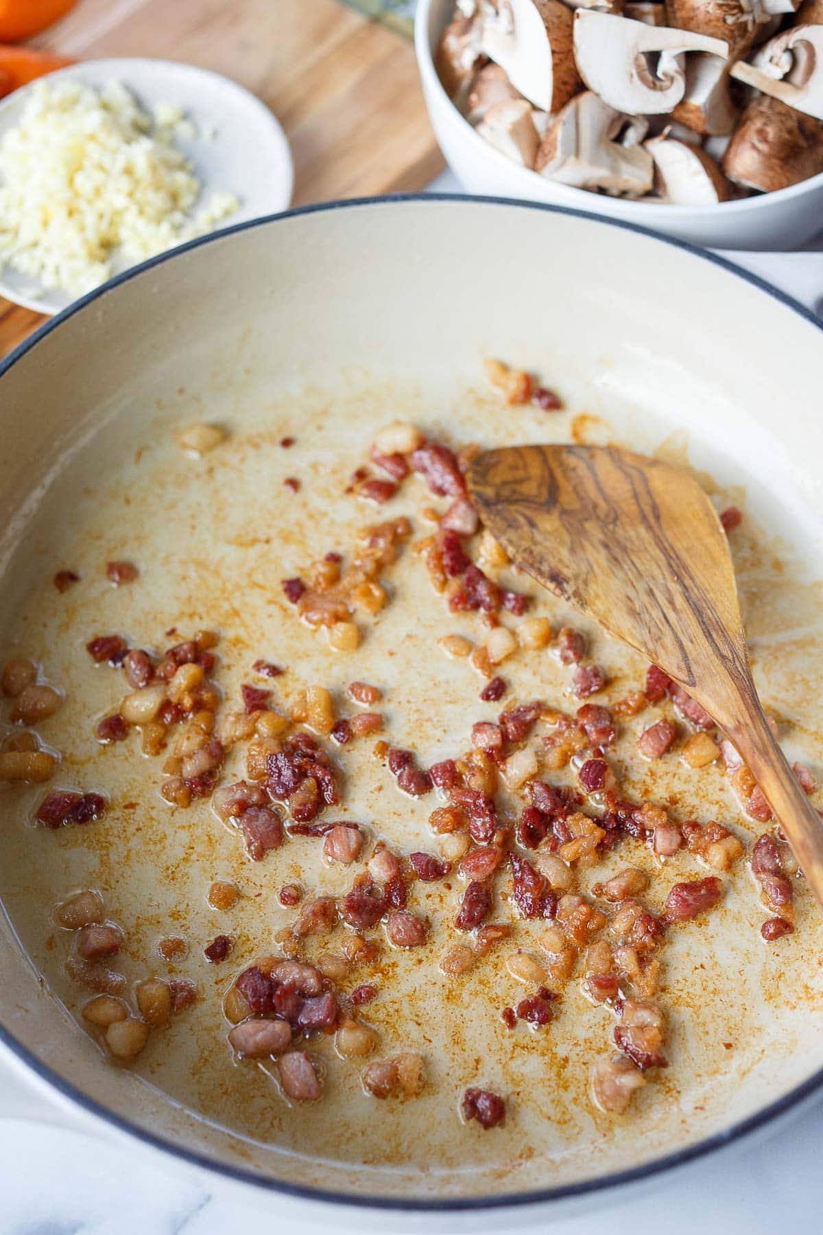 minced bacon cooking in pan for coq au vin.