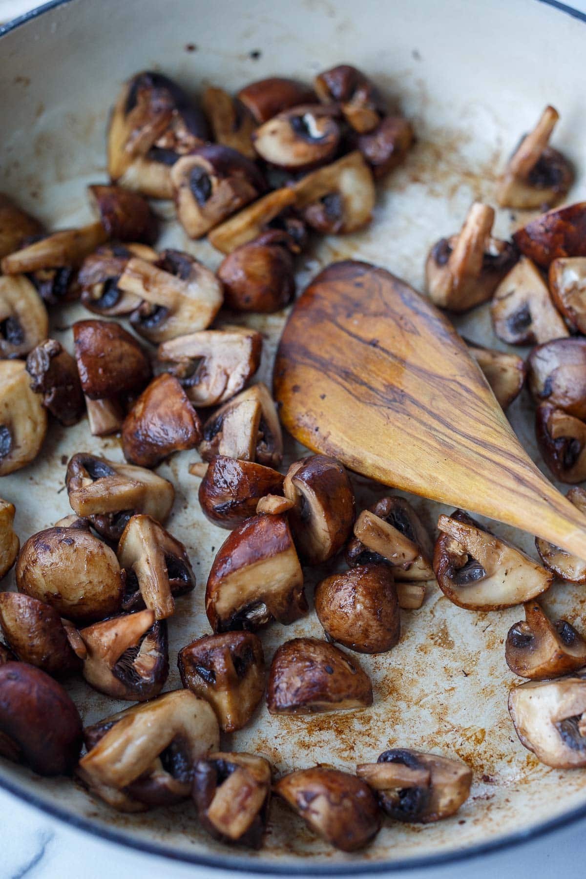 chopped mushrooms sautéing in pan.