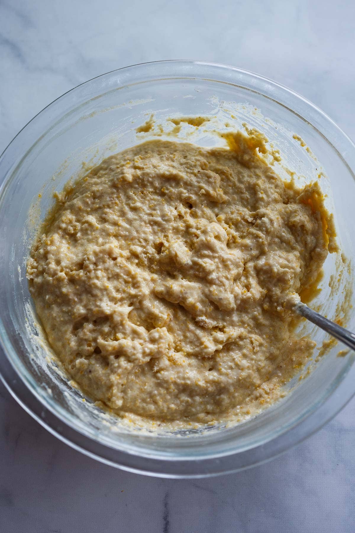 batter for vegan cornbread muffins in glass mixing bowl- gently folded together.