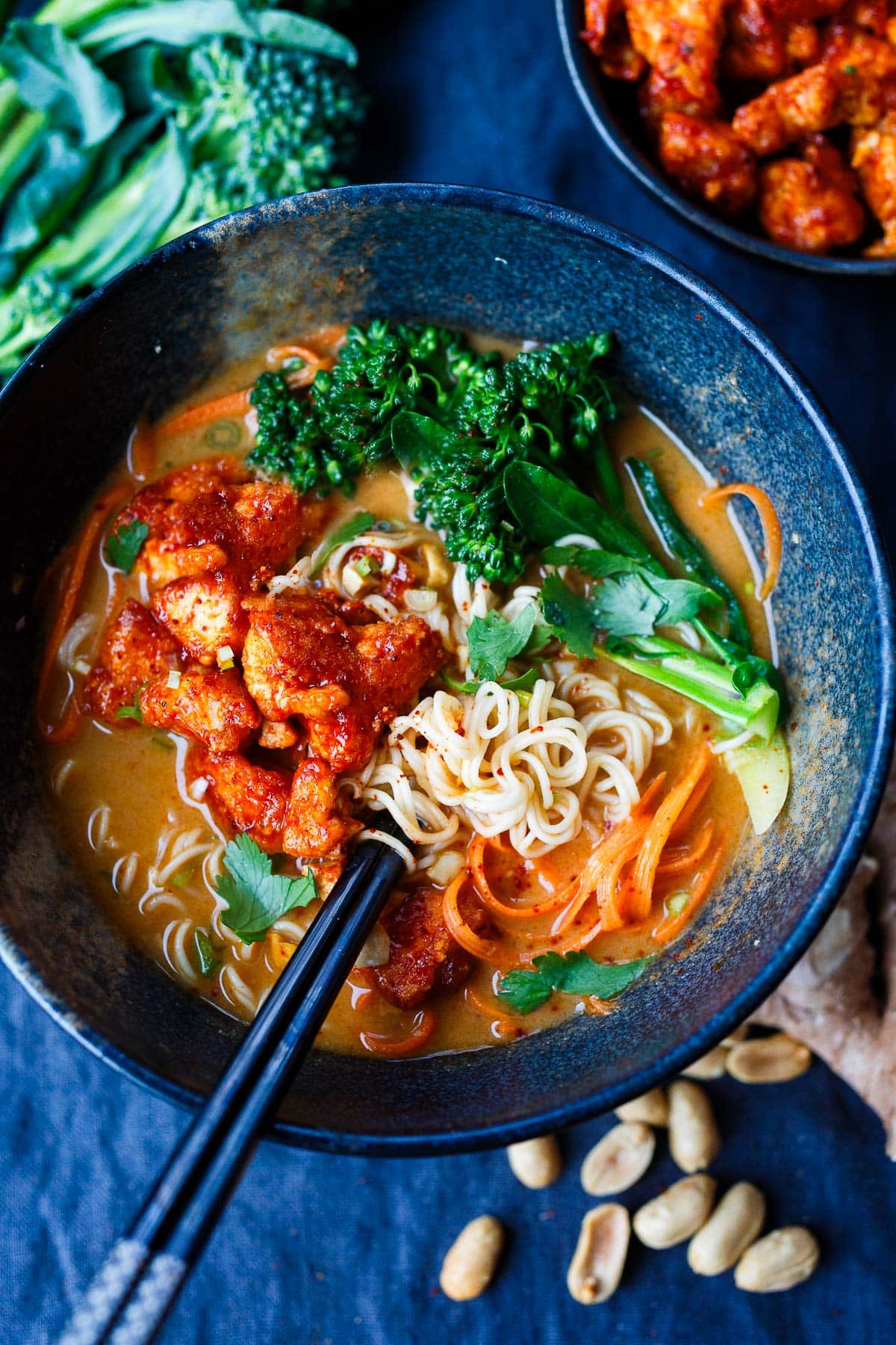 peanut butter ramen in bowl with crispy Korean tofu, colorful veggies, and ramen noodles.