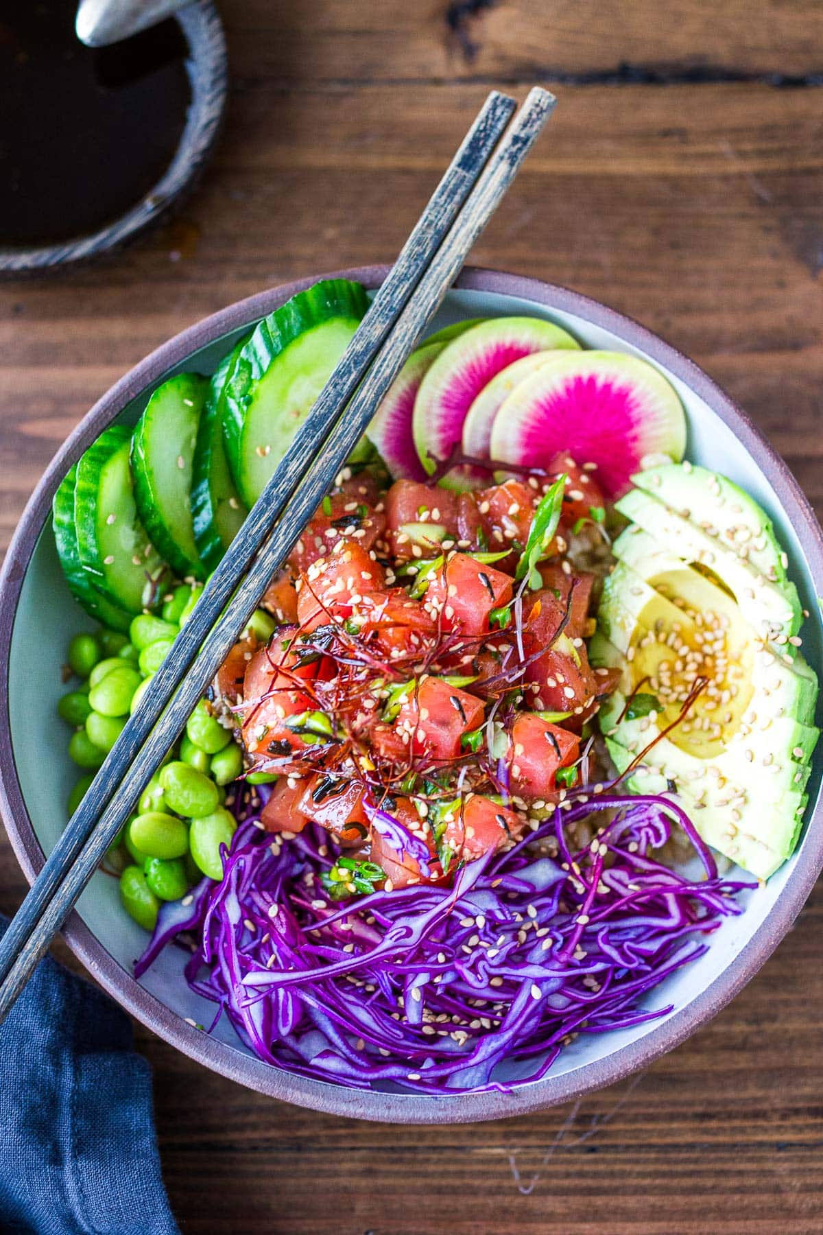 How to make your own homemade Hawaiian-style Poke Bowls made with fresh ahi tuna, rice, avocado, cucumbers, shredded cabbage, edamame, and a bright and flavorful Poke dressing.