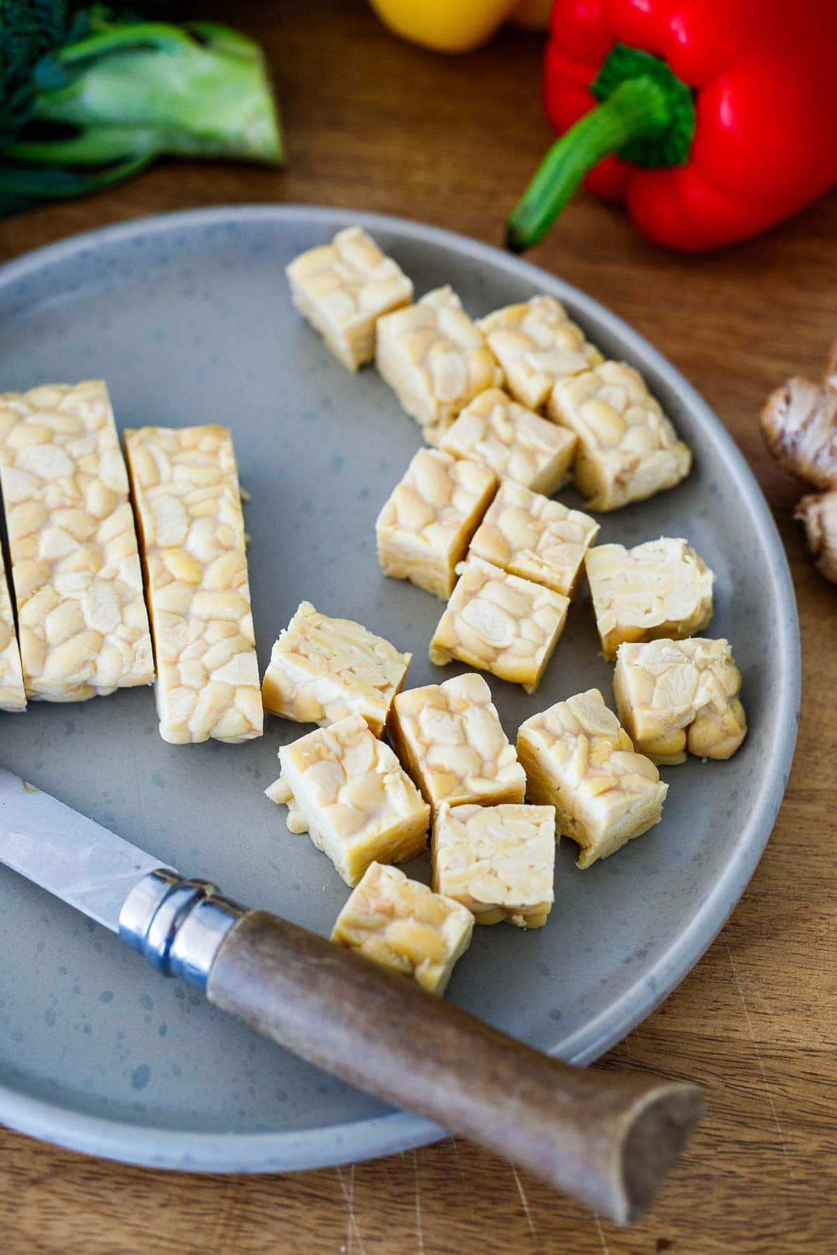 tempeh cubed on plate with knife.