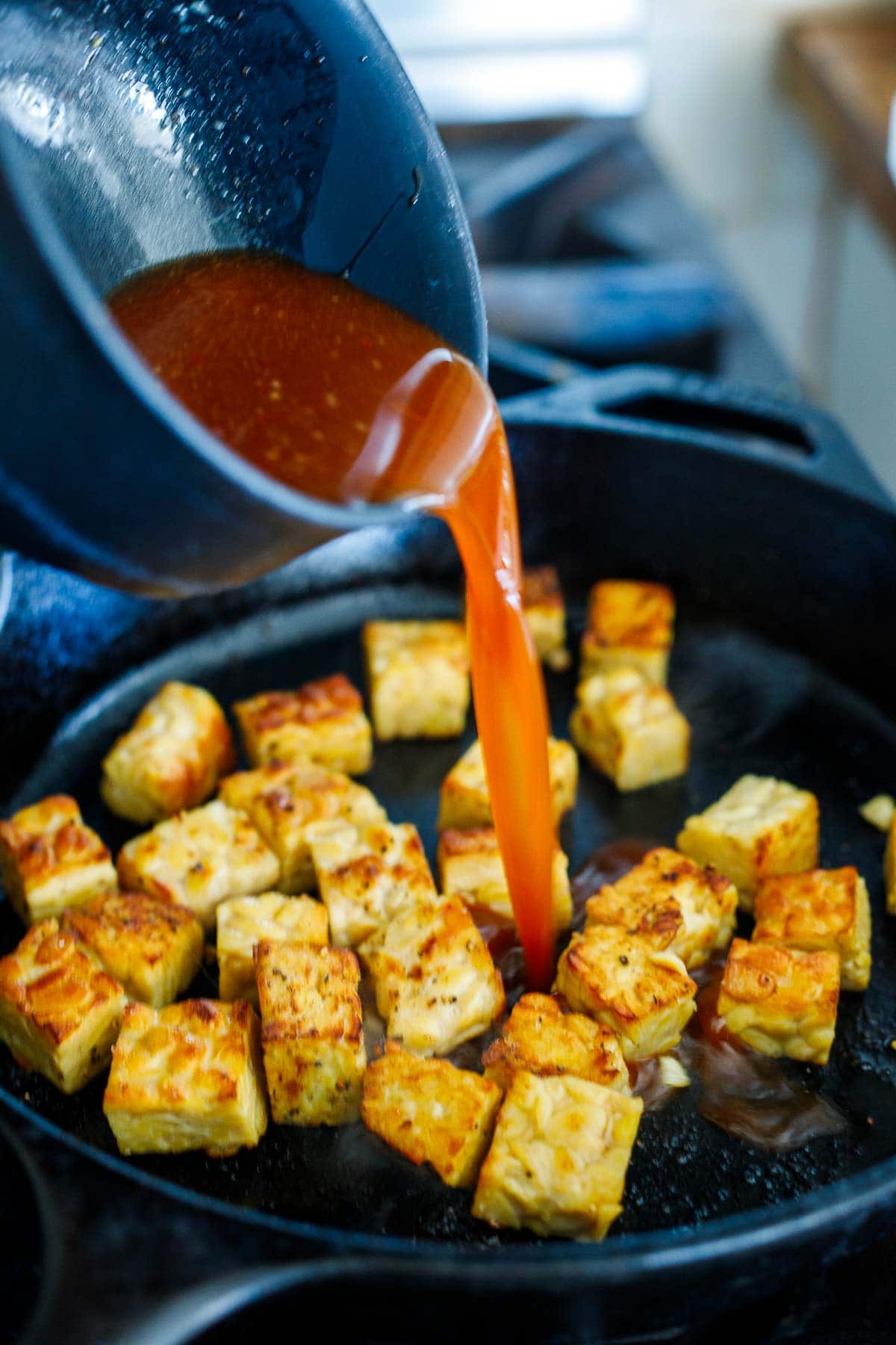 stir fry sauce poured over top of fried tempeh.