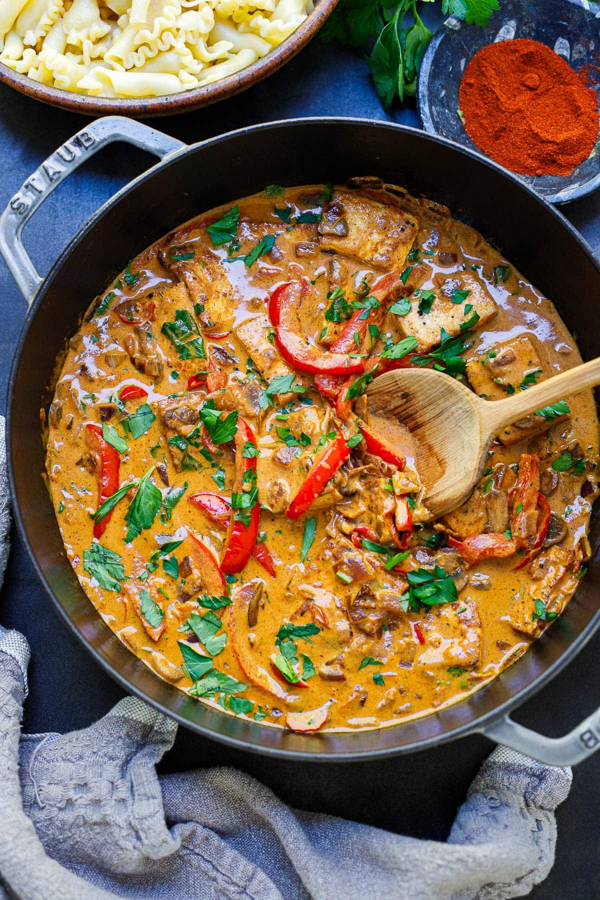 vegetarian paprikash simmering in skillet with tofu, red bell peppers, and fresh parsley.