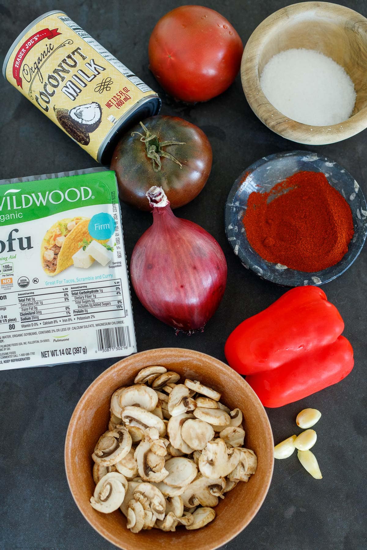 ingredients for vegan paprikash - tofu, sliced mushrooms, red bell pepper, red onion, garlic, tomato, coconut milk, salt.