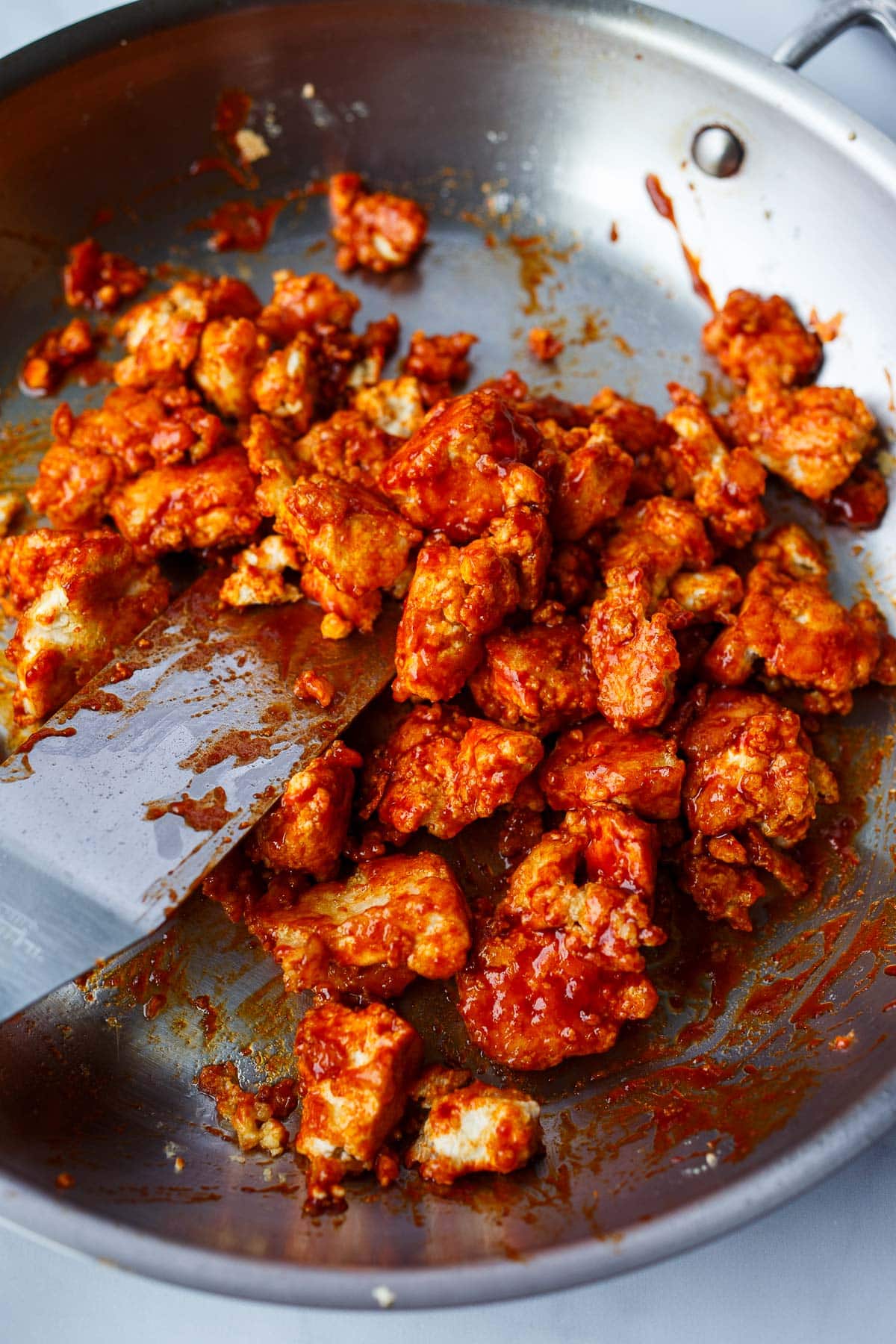 korean tofu in pan, coated in a gochujang sauce.