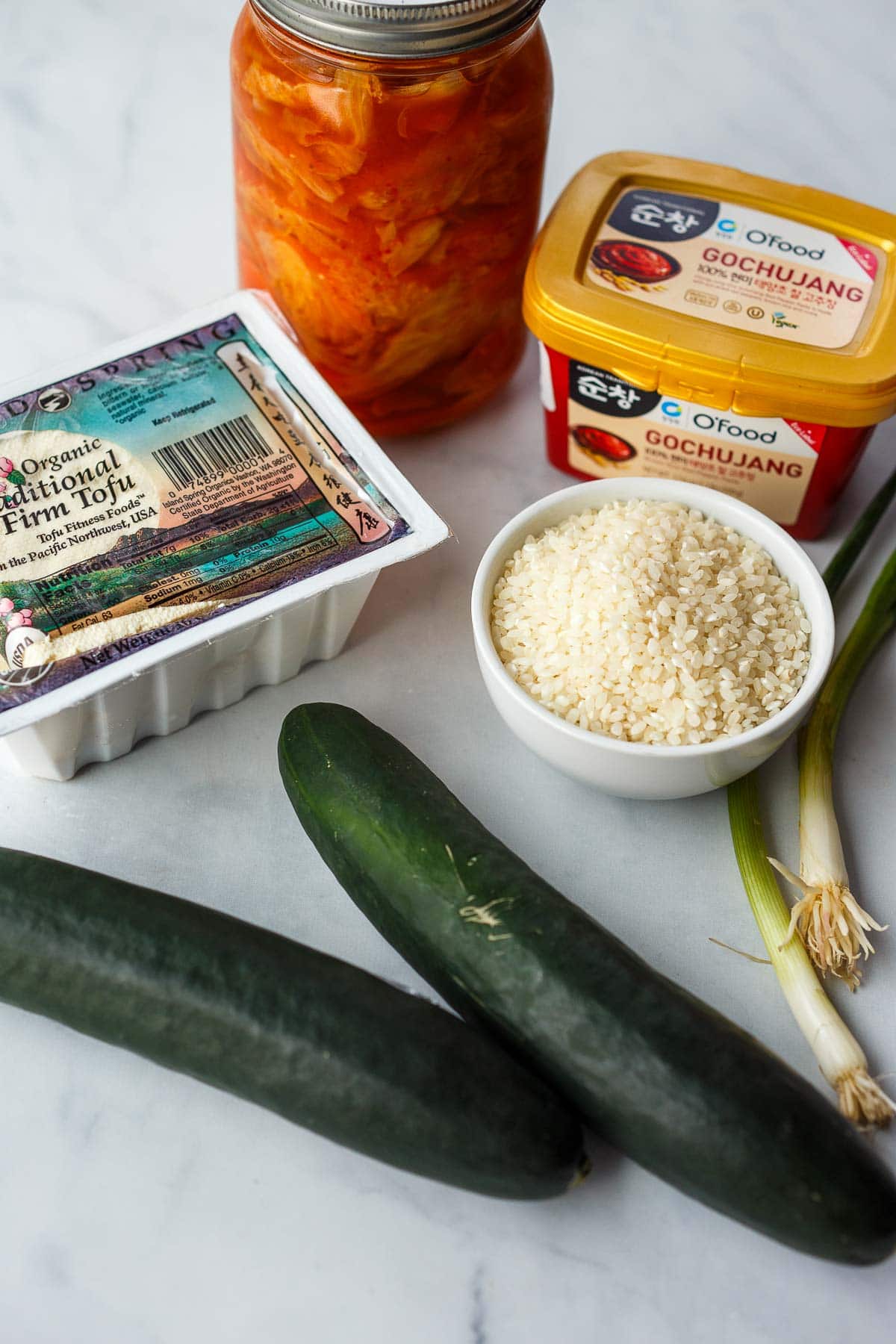 ingredients in korean tofu rice bowl - Tofu. jar of kimchi, gochujang, firm tofu, jasmine rice, scallions, cucumber.