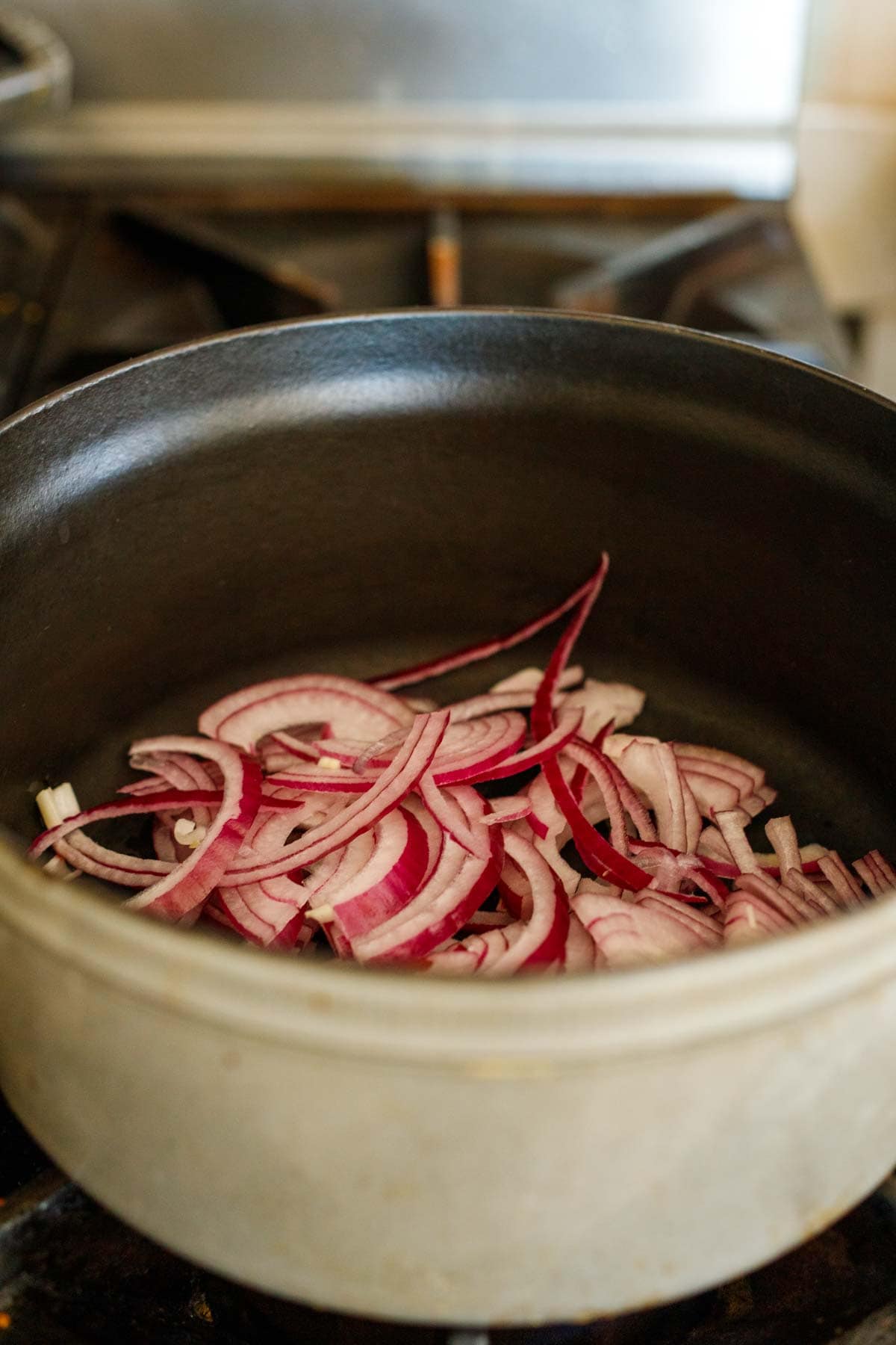 sliced red onion sautéing in dutch oven.