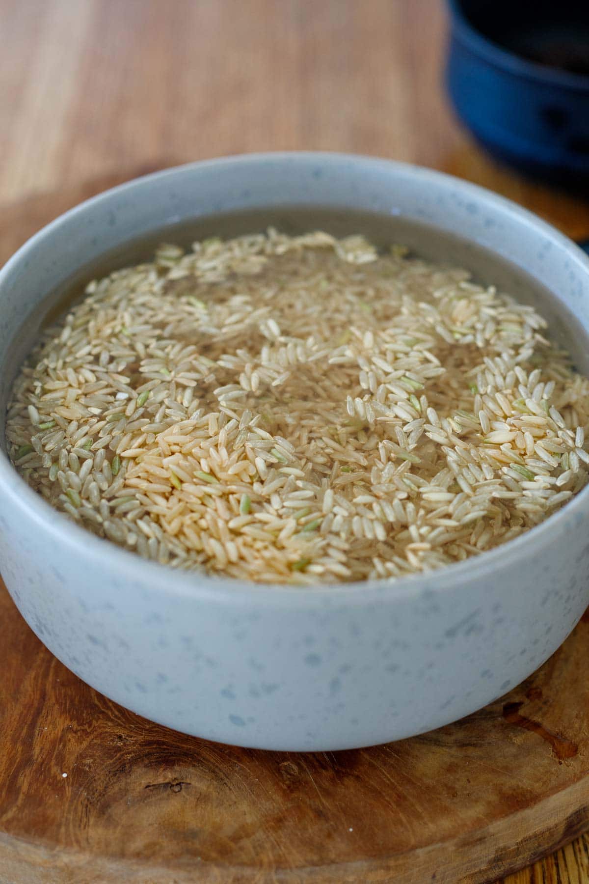 soaking brown basmati rice in water in bowl to make Moroccan rice pilaf.
