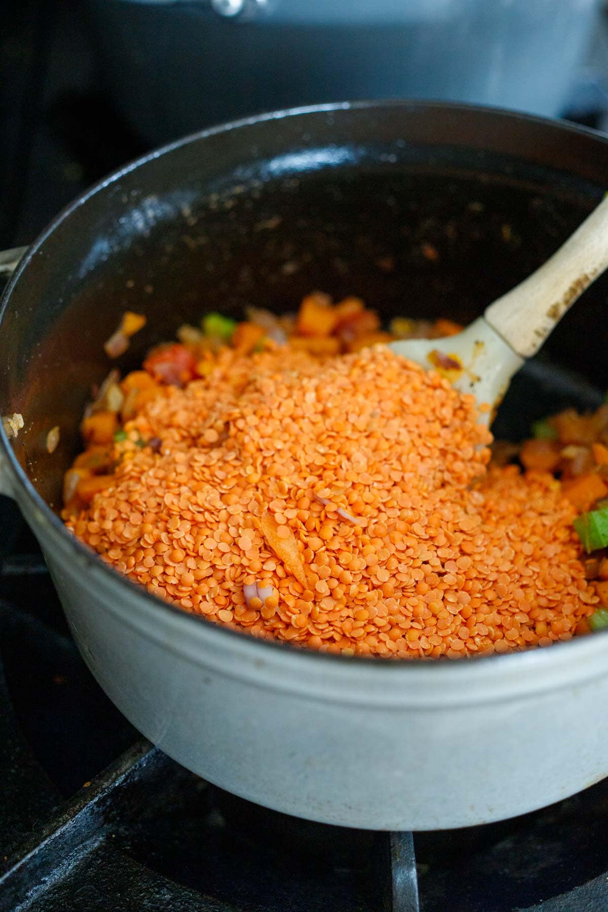 red lentils added to dutch oven with cooked vegetables.