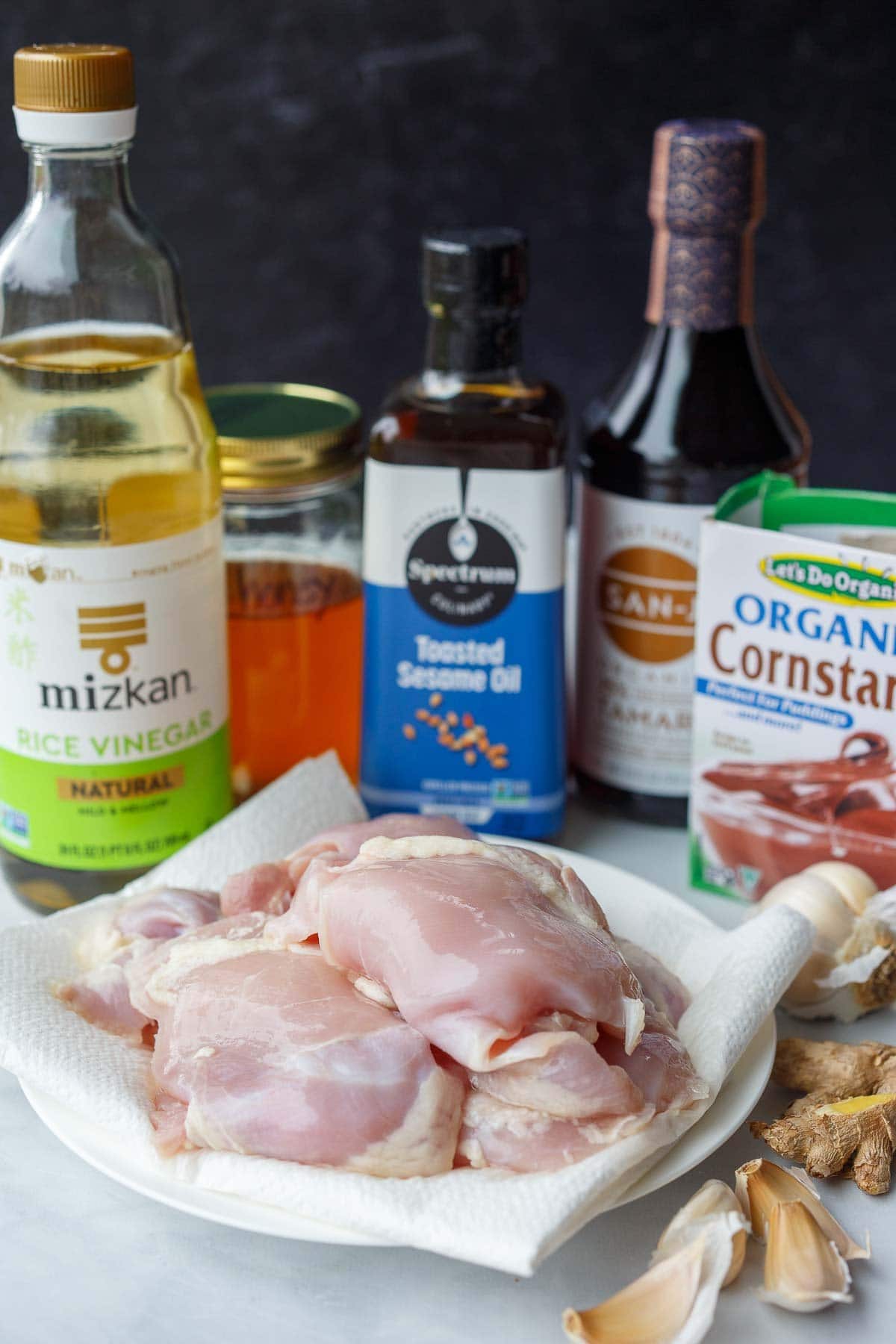 ingredients for instant pot teriyaki chicken- chicken thighs, rice vinegar, toasted sesame oil, tamari, cornstarch, garlic, ginger.