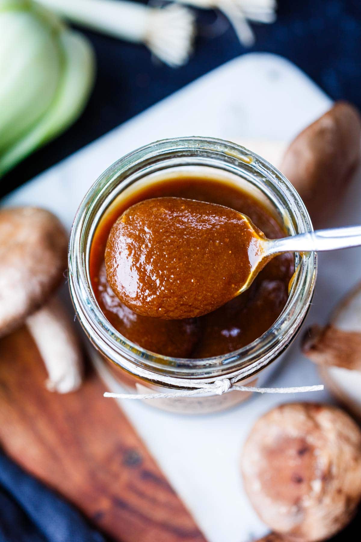 jar of homemade vegan oyster sauce with spoonful of sauce over jar.